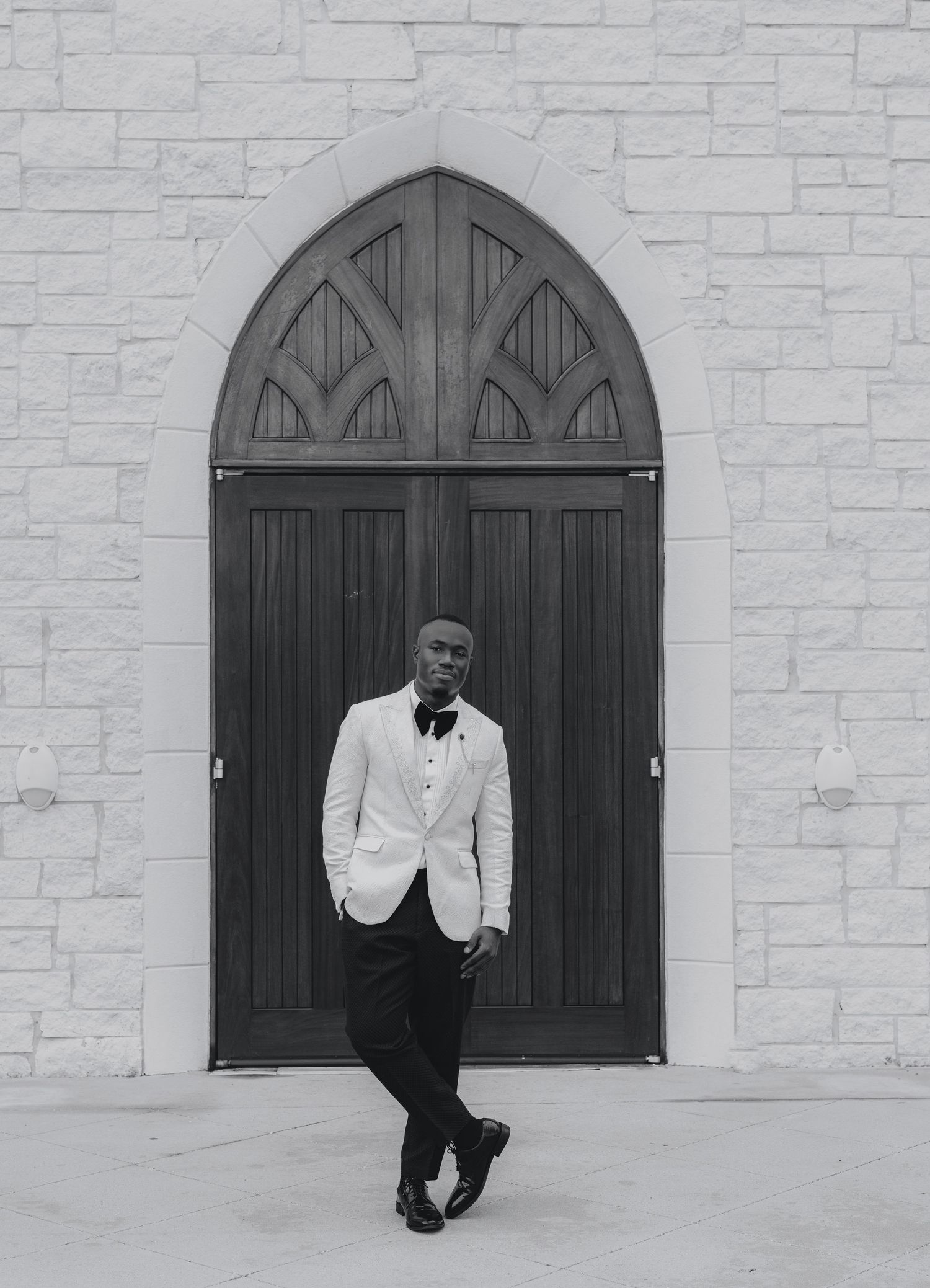A series of artistic black and white portraits taken against a stone church wall with arched windows.