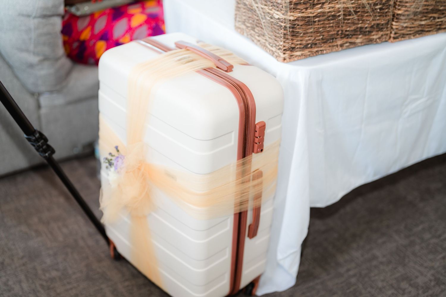Woven baskets and white containers arranged on tables at a wedding reception.
