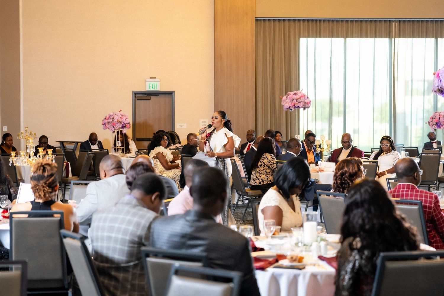 A group of people seated in rows at a corporate conference or business meeting in a modern event space.