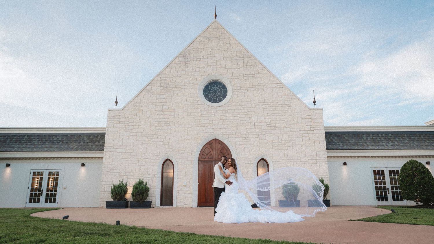 Panoramic view of a modern white church building with geometric architecture against a blue sky.