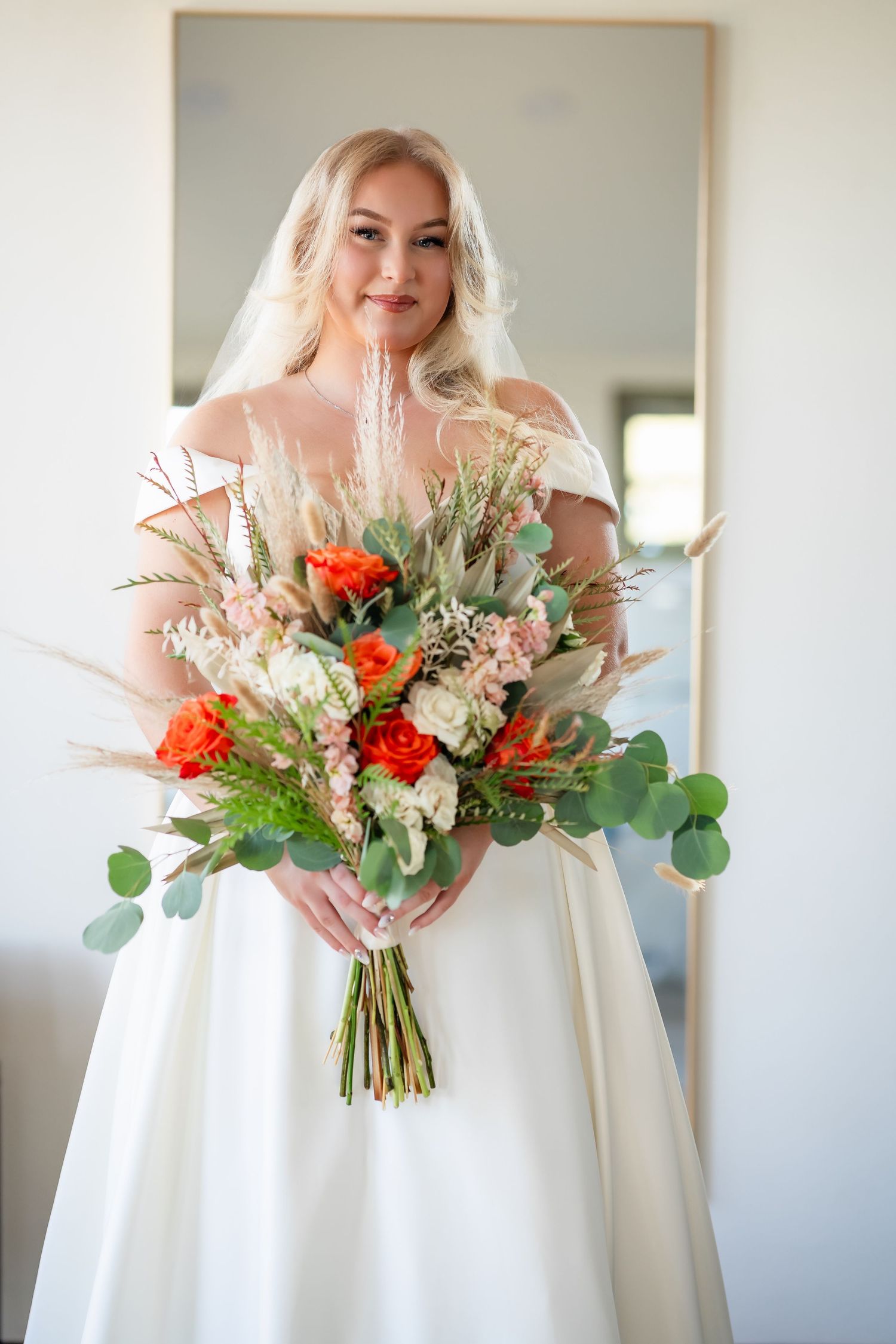 Elegant white wedding dress with vibrant coral and greenery bouquet shown in multiple detail shots.