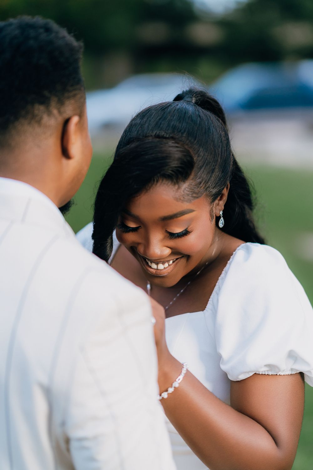 A romantic outdoor photo series showing tender moments between a couple in white attire during their wedding photoshoot.