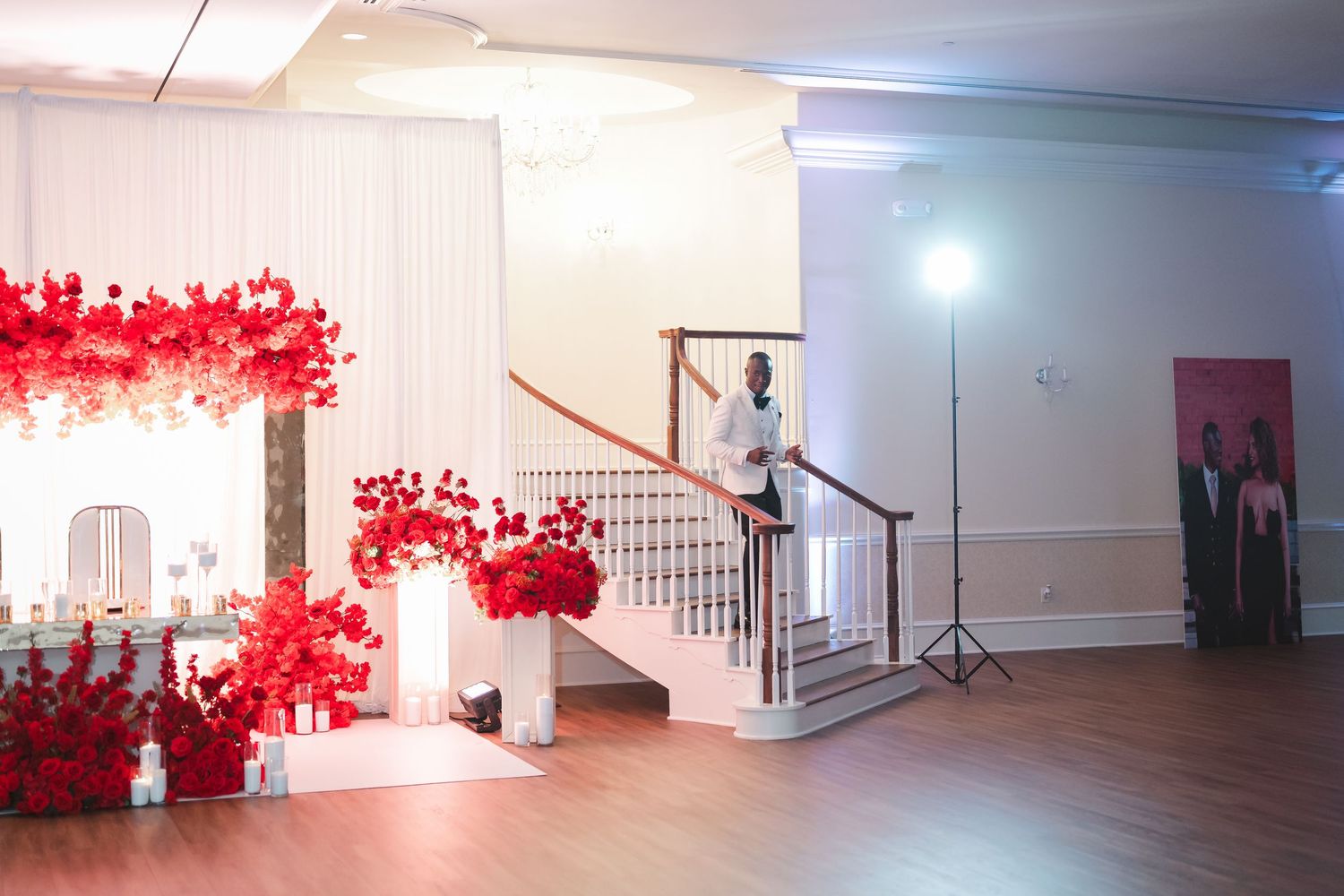 Wedding venue interior with dramatic red floral wall decorations and white walls.