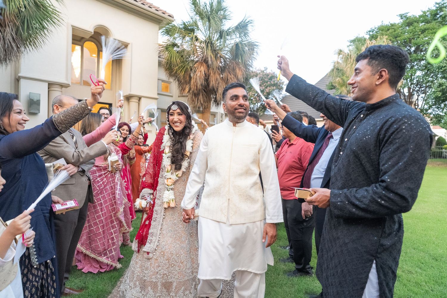 Wedding party celebrates outdoors with festive dancing and entertainment.
