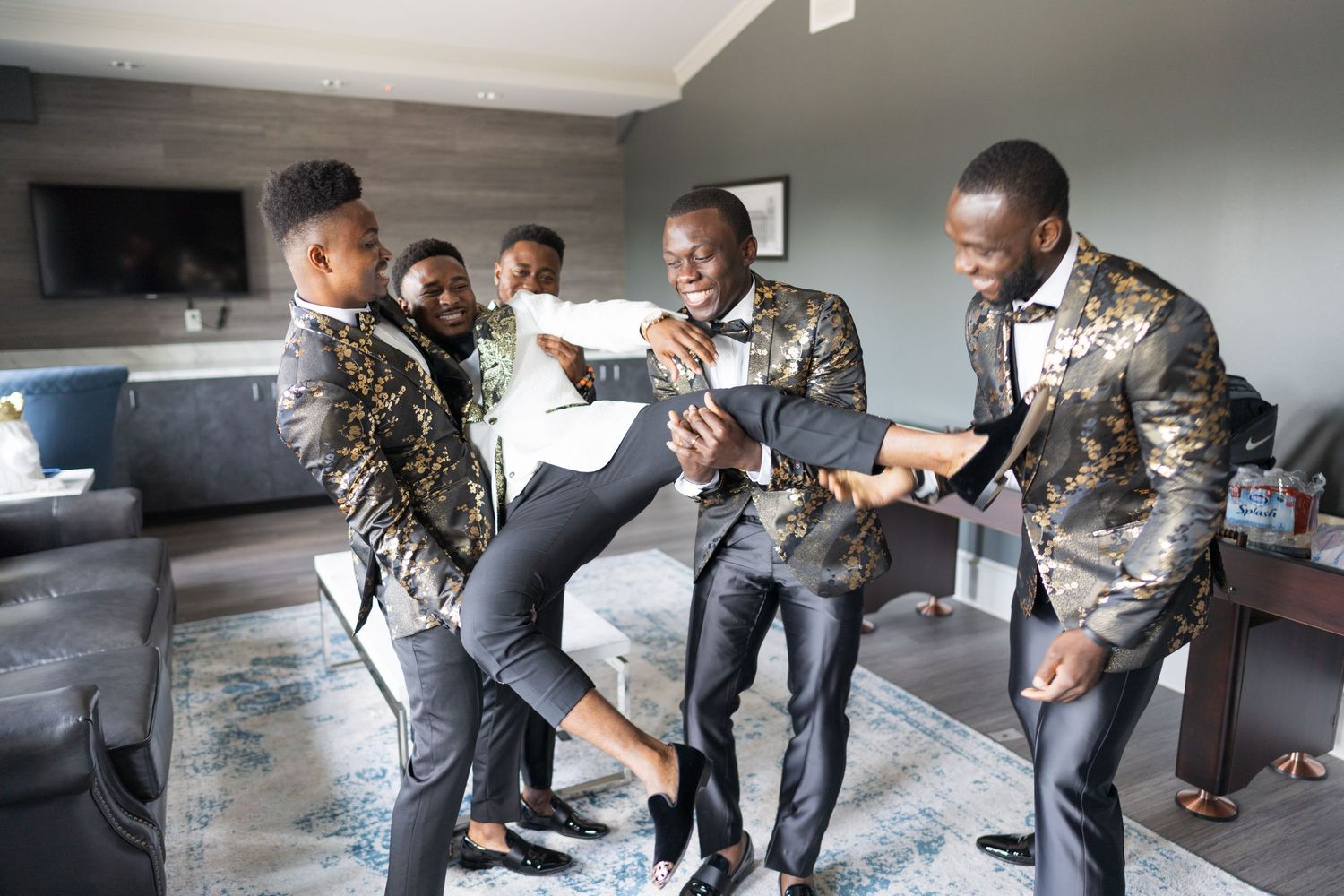 Wedding party members in camouflage attire playfully posing together indoors.