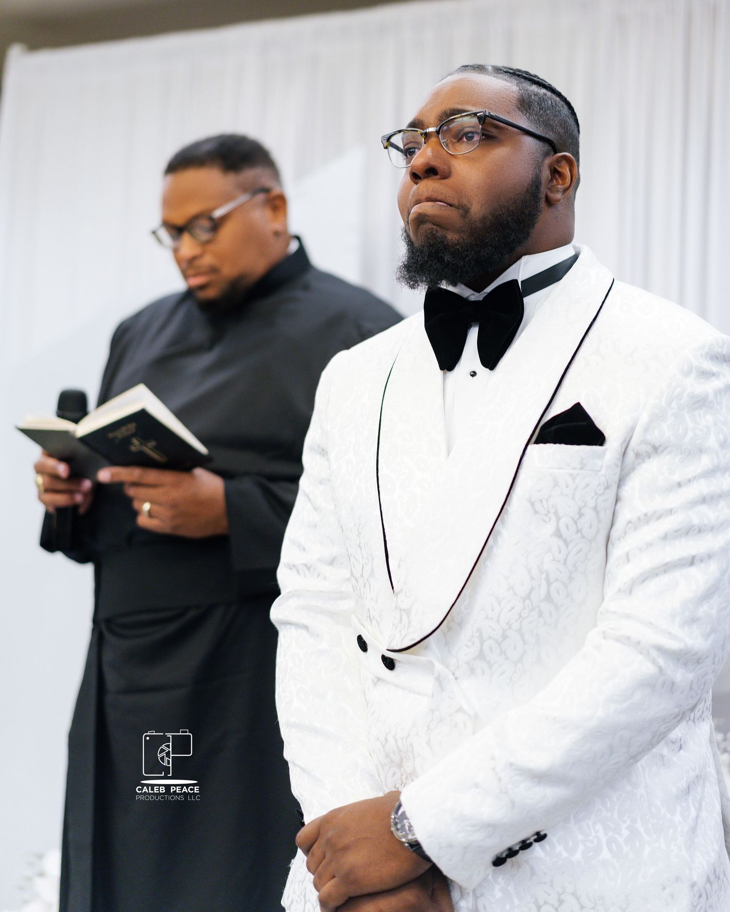 Wedding party members in black and white formal attire gathered for a ceremony.