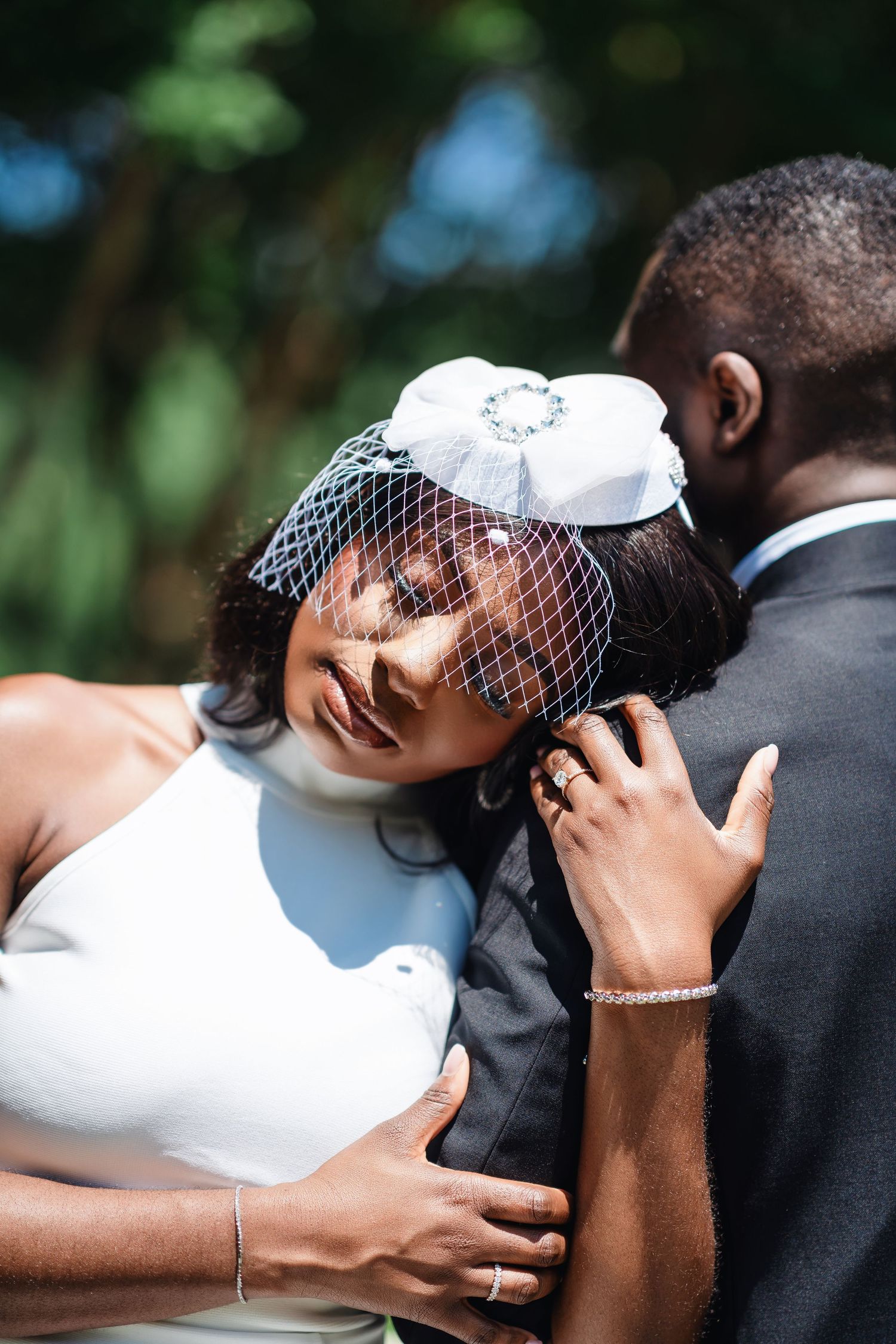 A tender moment captured between a couple in wedding attire with the bride wearing a vintage-style veil.