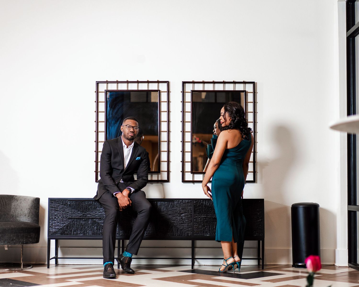 A series of connected black and white photos showing people posing against a white wall in a modern interior space.