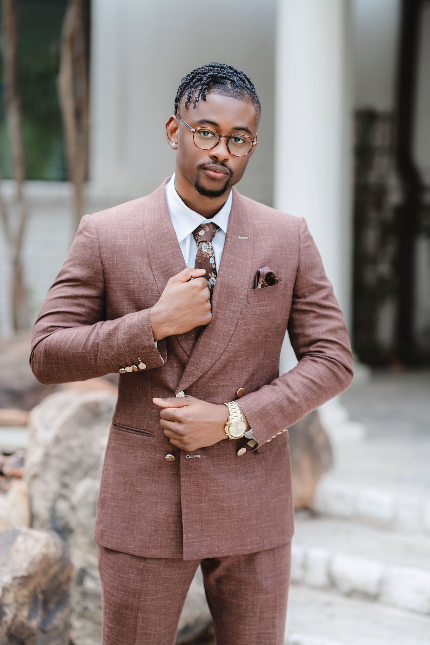 A stylish brown plaid suit is showcased in multiple poses against a light outdoor backdrop.