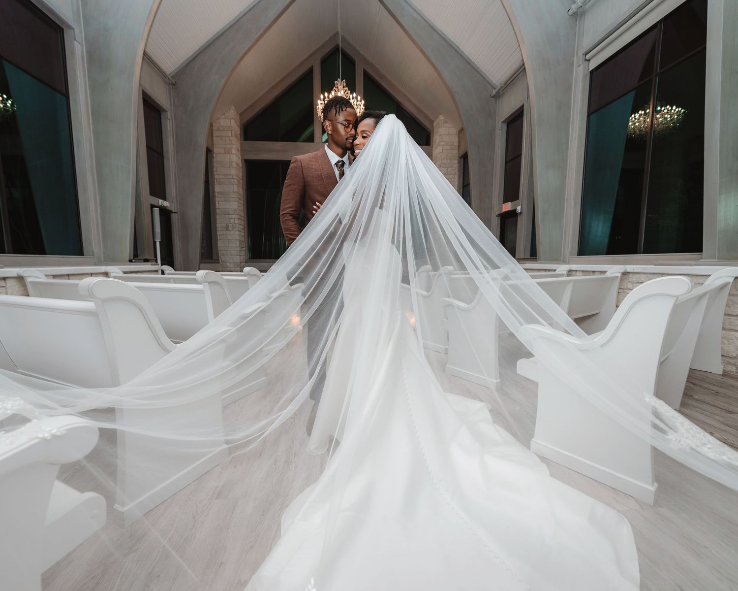 Long flowing white wedding dress train displayed dramatically in an elegant indoor venue.