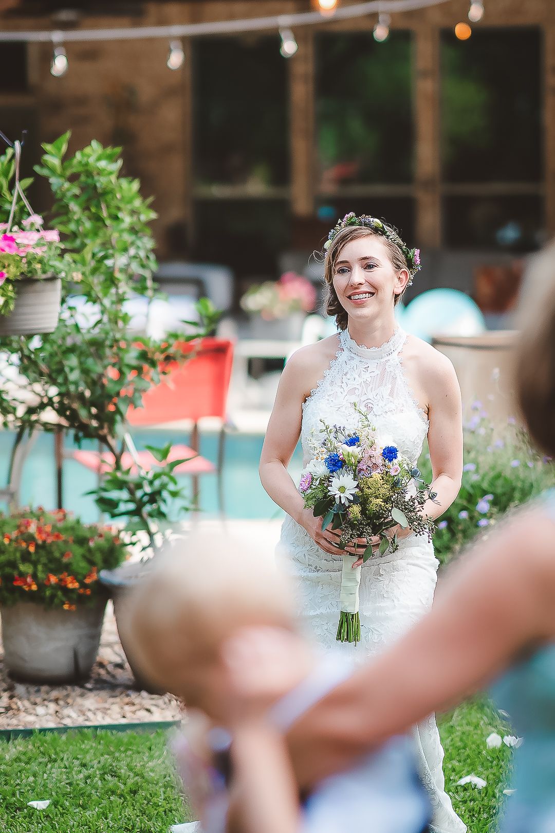 A joyful outdoor wedding scene with floral arrangements and string lights.