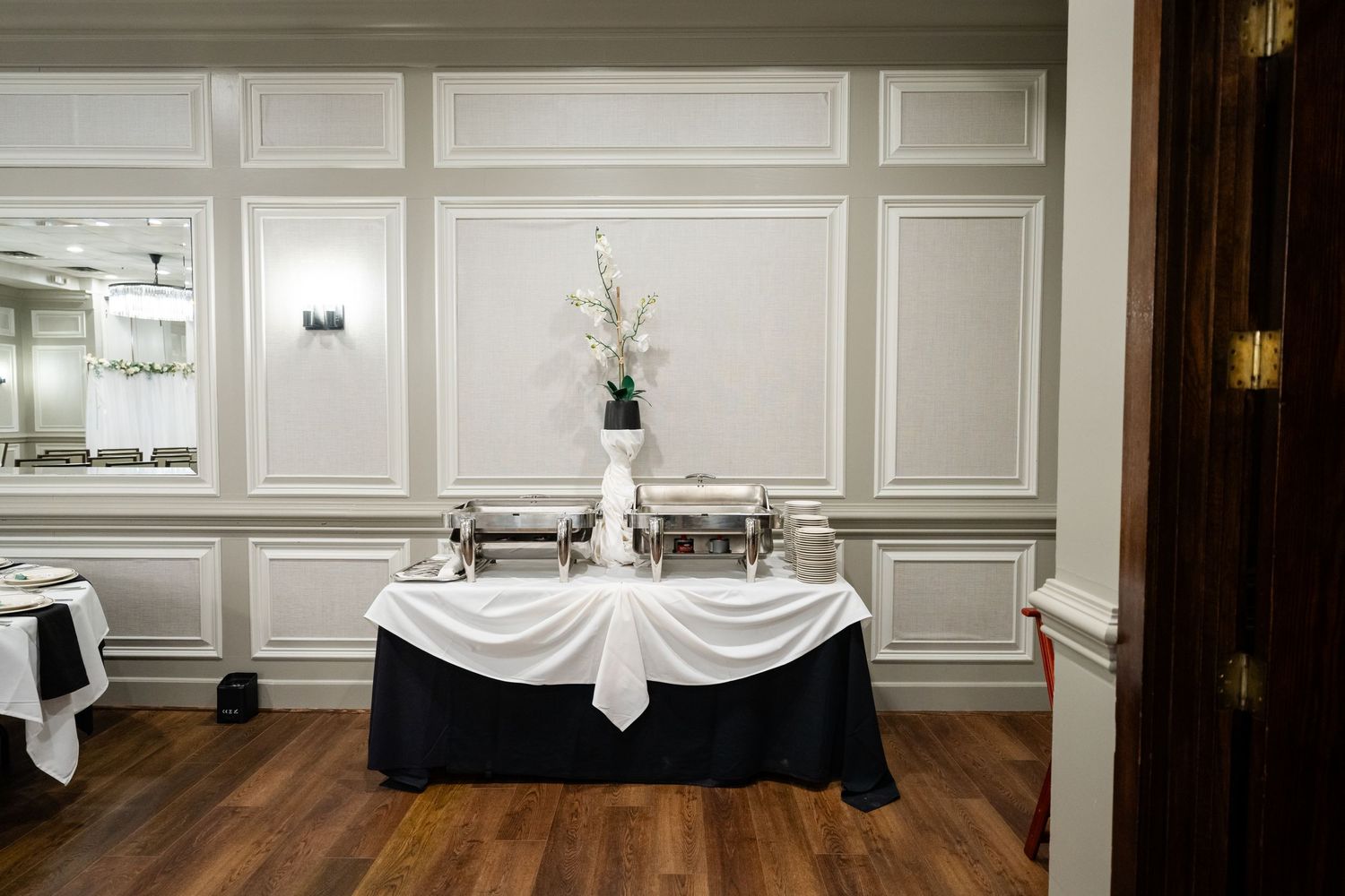 Elegant white paneled walls and hardwood floors in wedding venue interior.