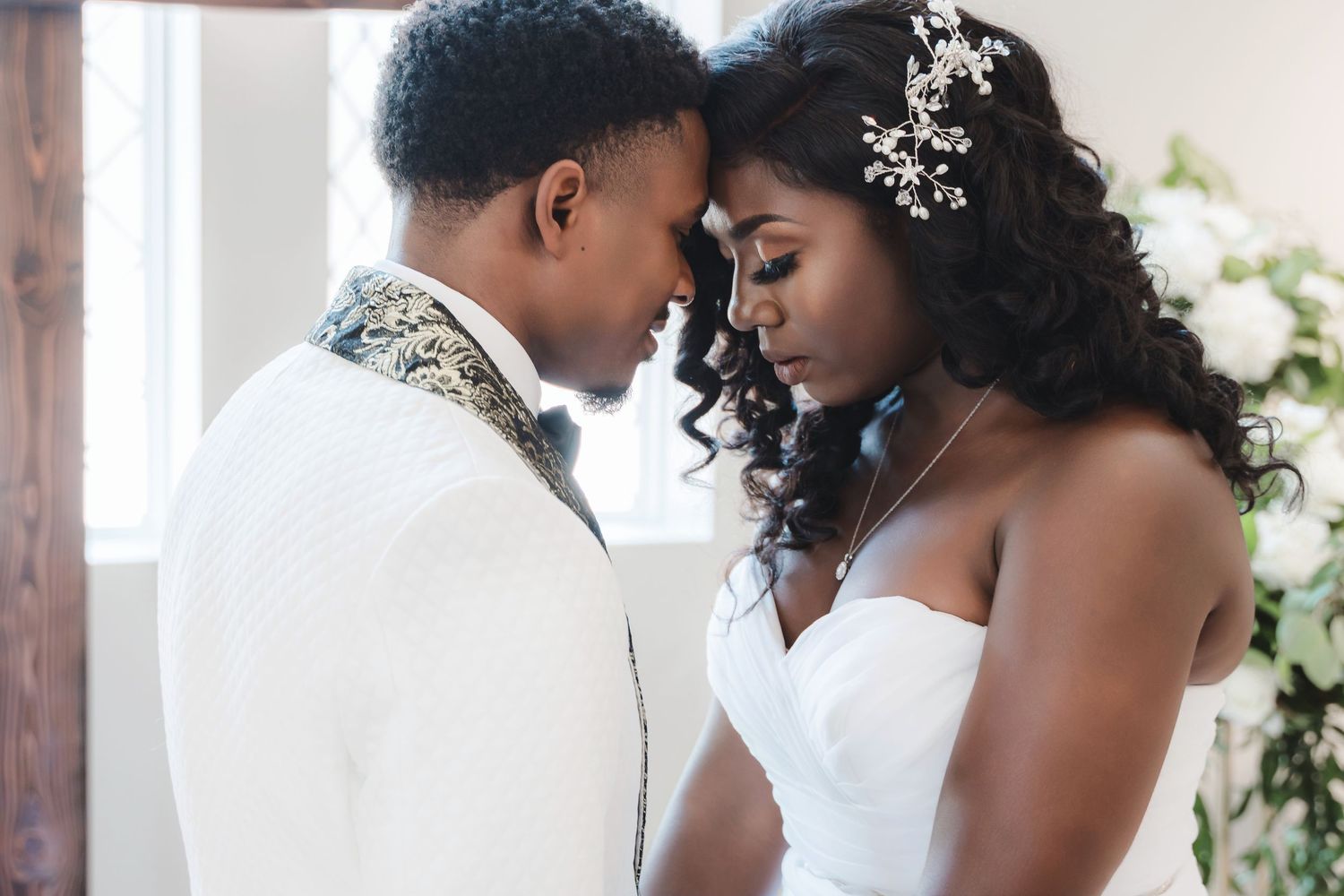 A tender moment shared between two people in a bright room with soft natural lighting.