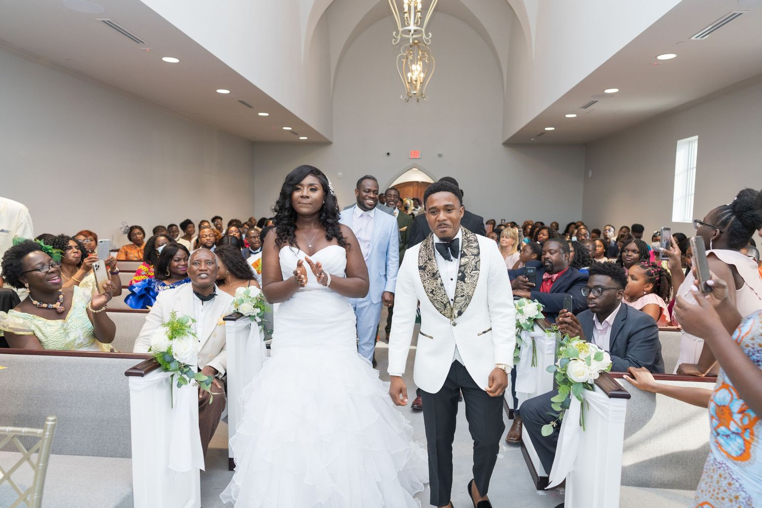 A wedding ceremony in a bright church with guests seated in pews.