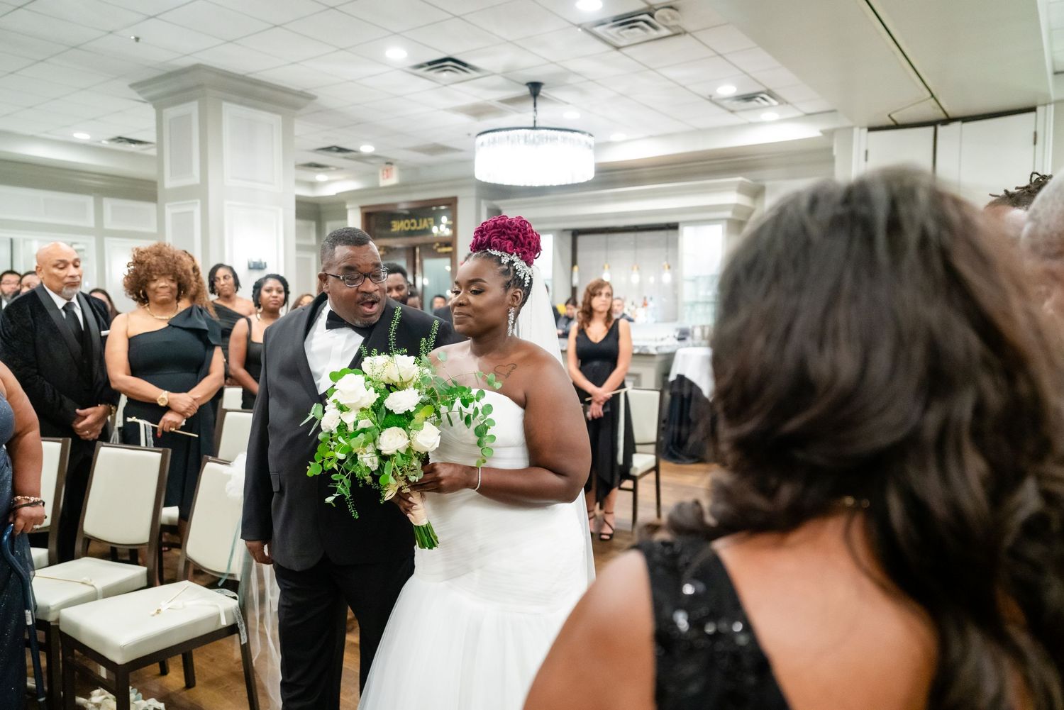 Wedding reception celebration with guests gathered in an elegant indoor venue.