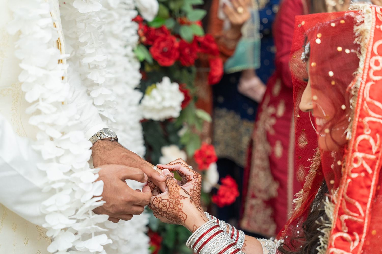 Wedding ceremony decor featuring white floral arrangements and red accents.