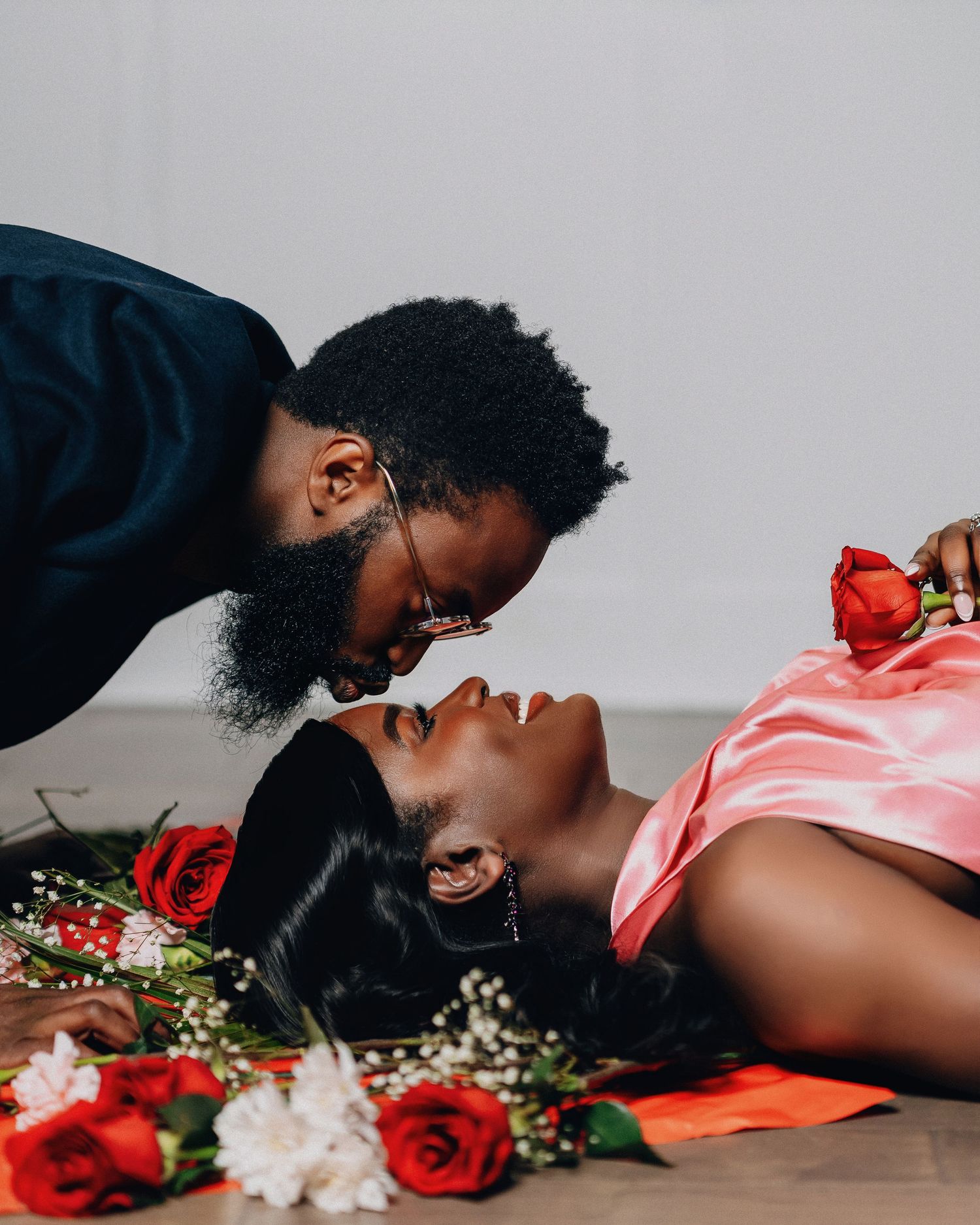 Intimate artistic portrait with roses and flowers showing a romantic moment between a couple.