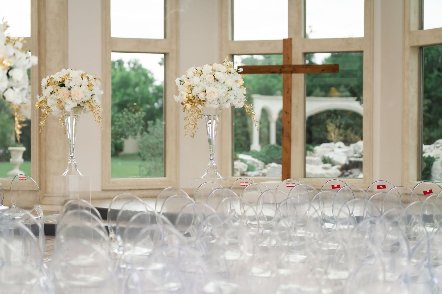 Elegant wedding reception venue with crystal chandeliers and glassware set on long tables with white linens.