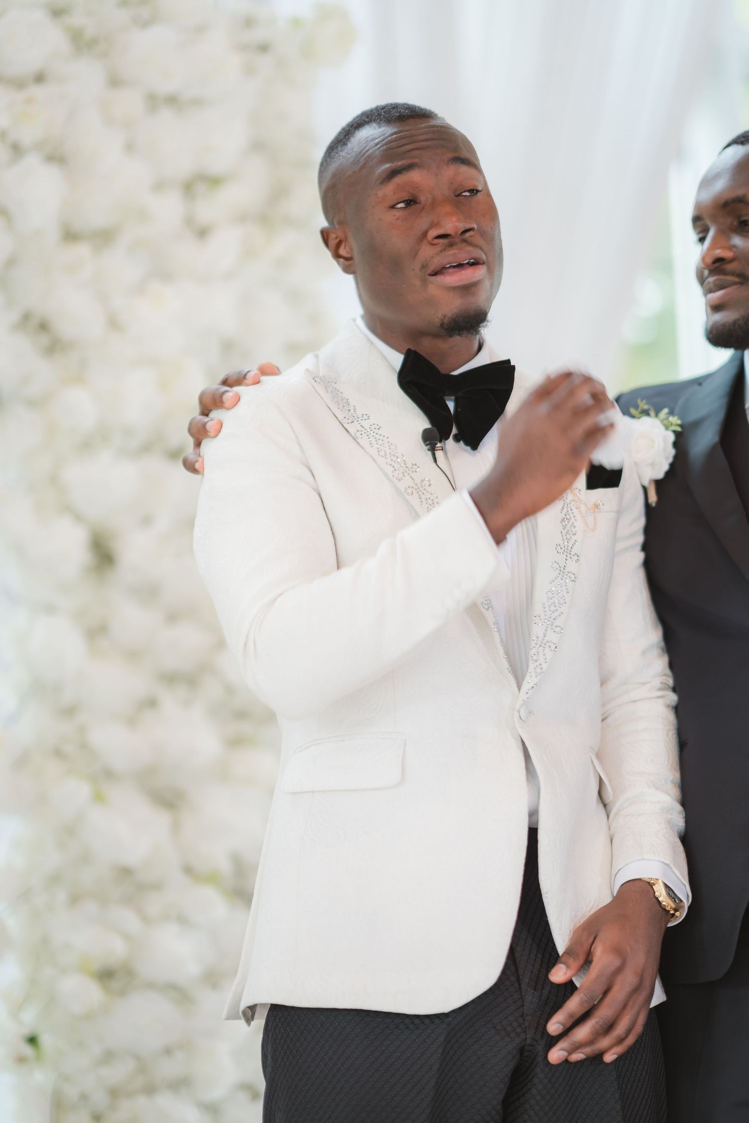 Wedding party members in formal attire share a candid moment during celebrations.