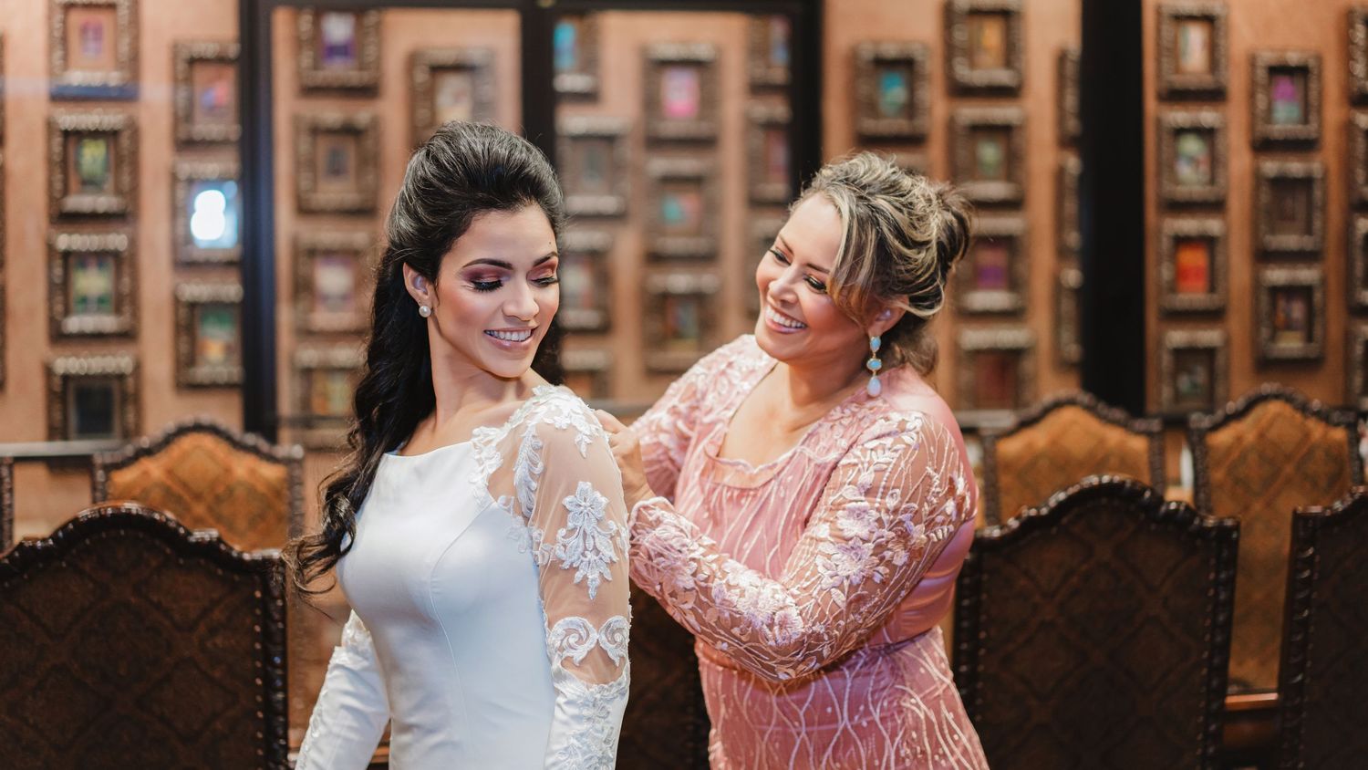 Wedding party poses in elegant wood-paneled library with ornate carved chairs.