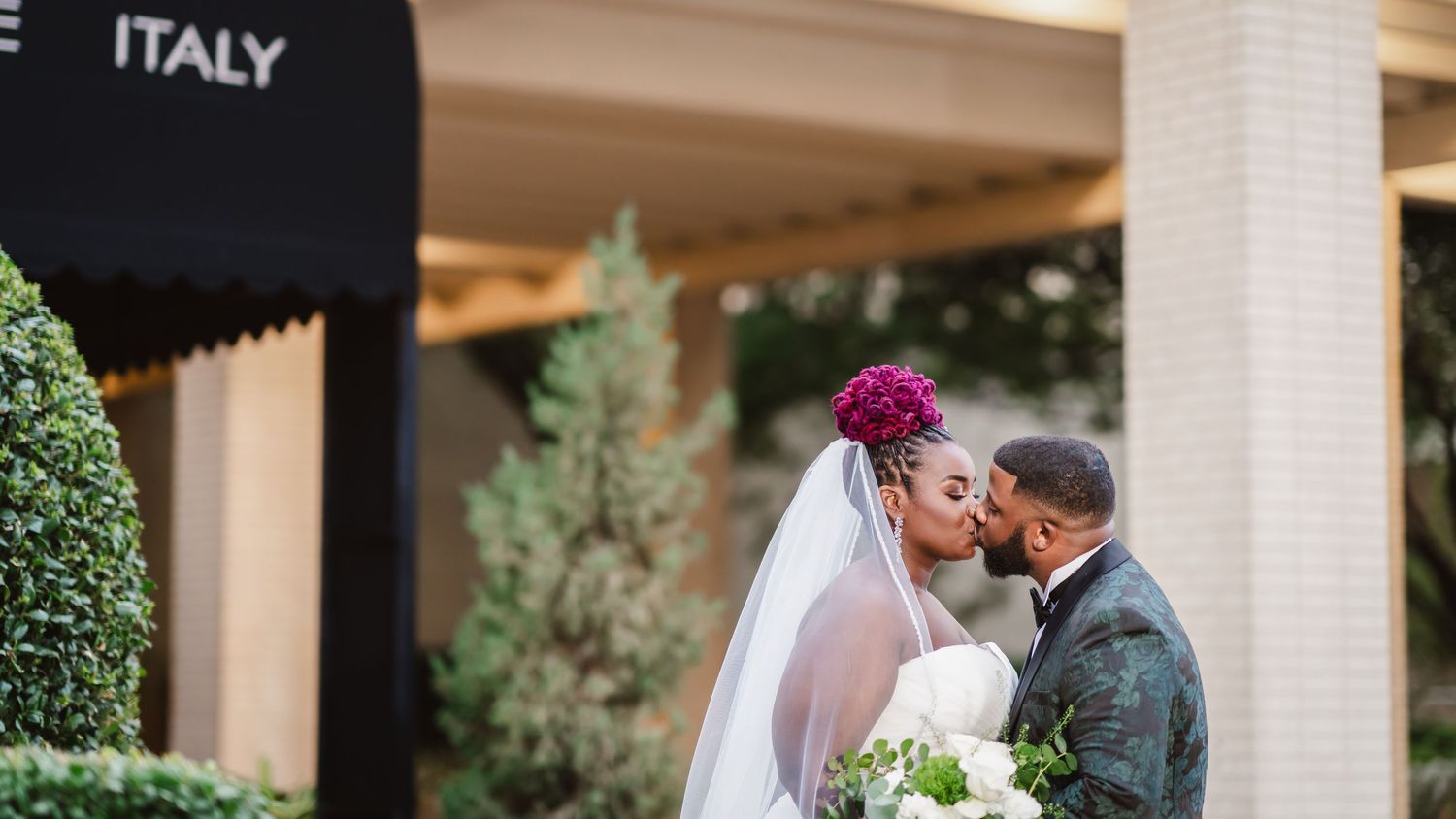 Wedding couple shares intimate moments outside Italian restaurant with elegant decor.