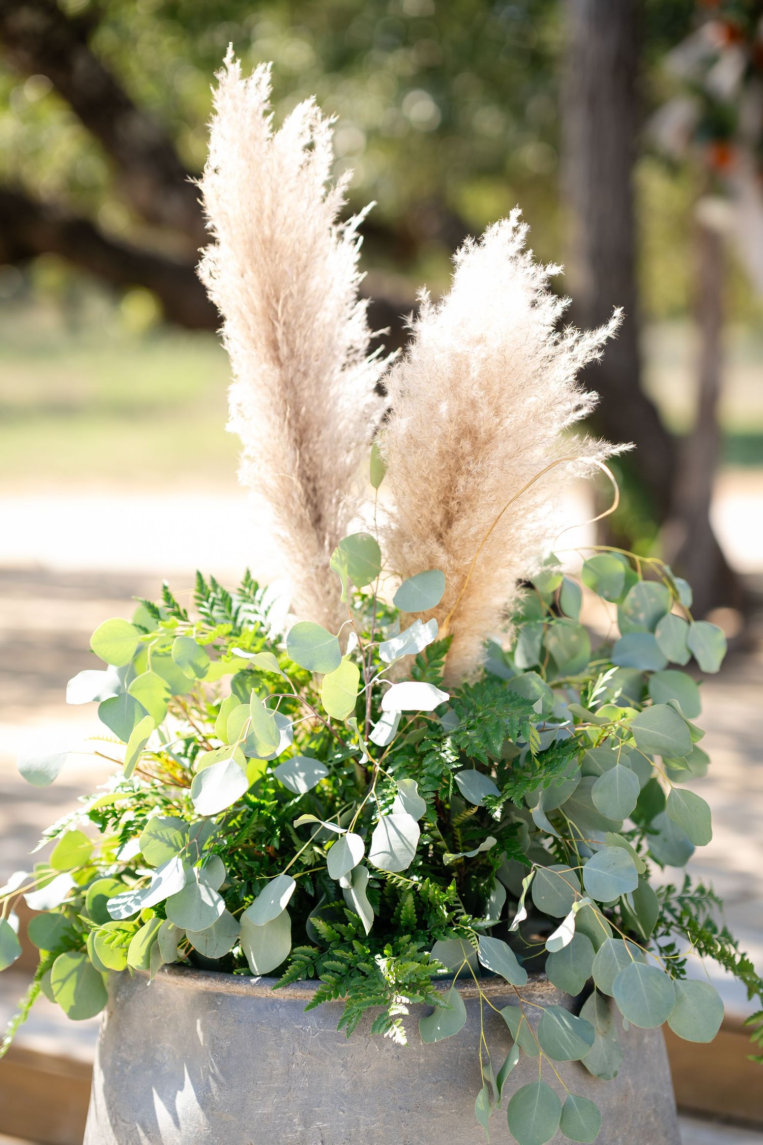 Elegant floral arrangement with pampas grass and eucalyptus leaves in natural outdoor lighting.