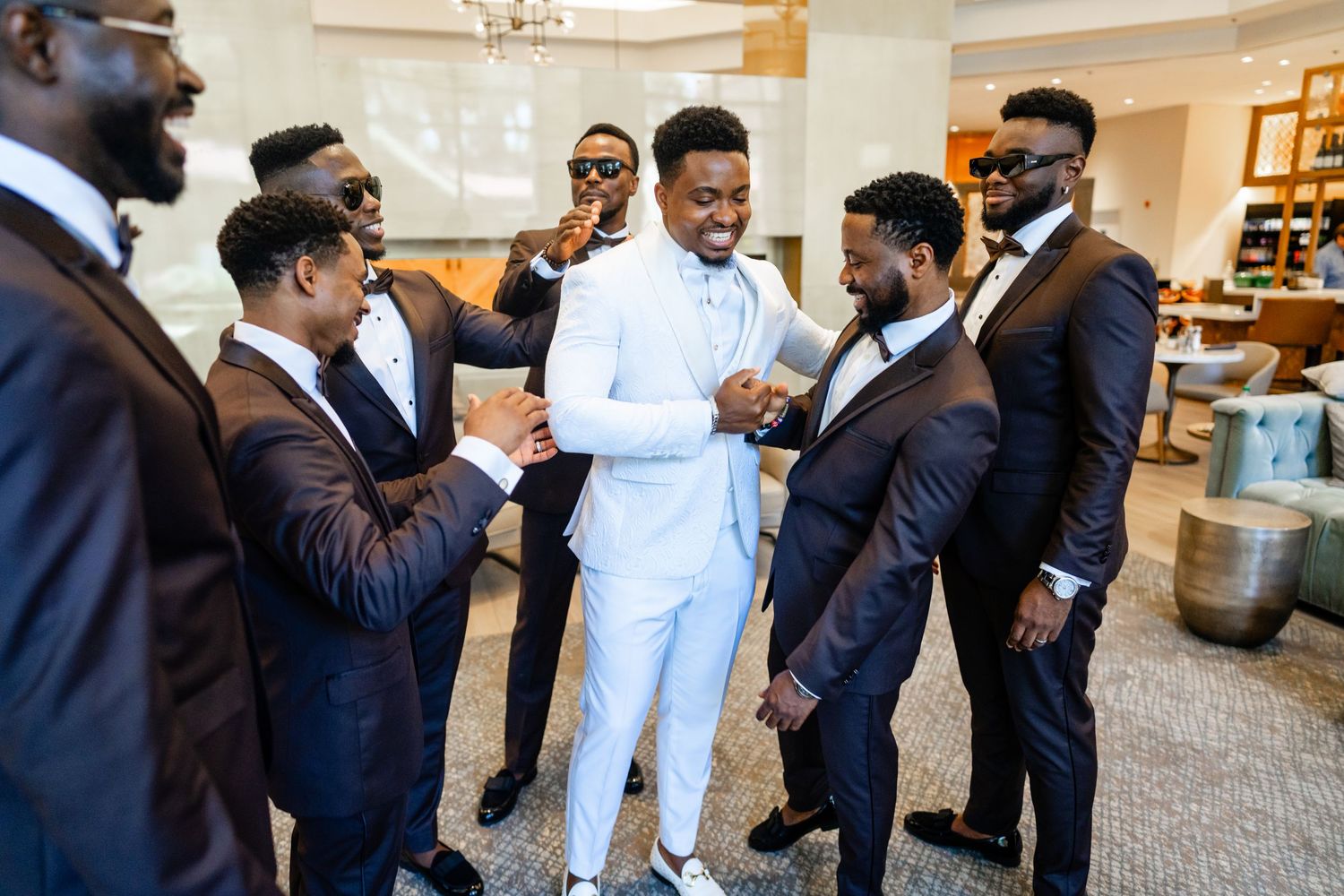 Groomsmen in navy suits gather together before the wedding ceremony.
