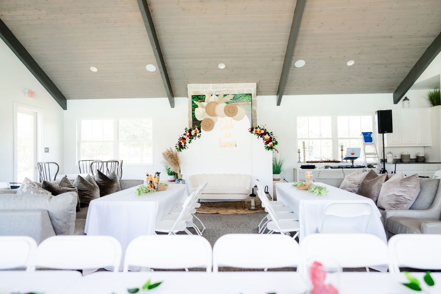 Large bright white interior space with exposed beams and modern furnishings.