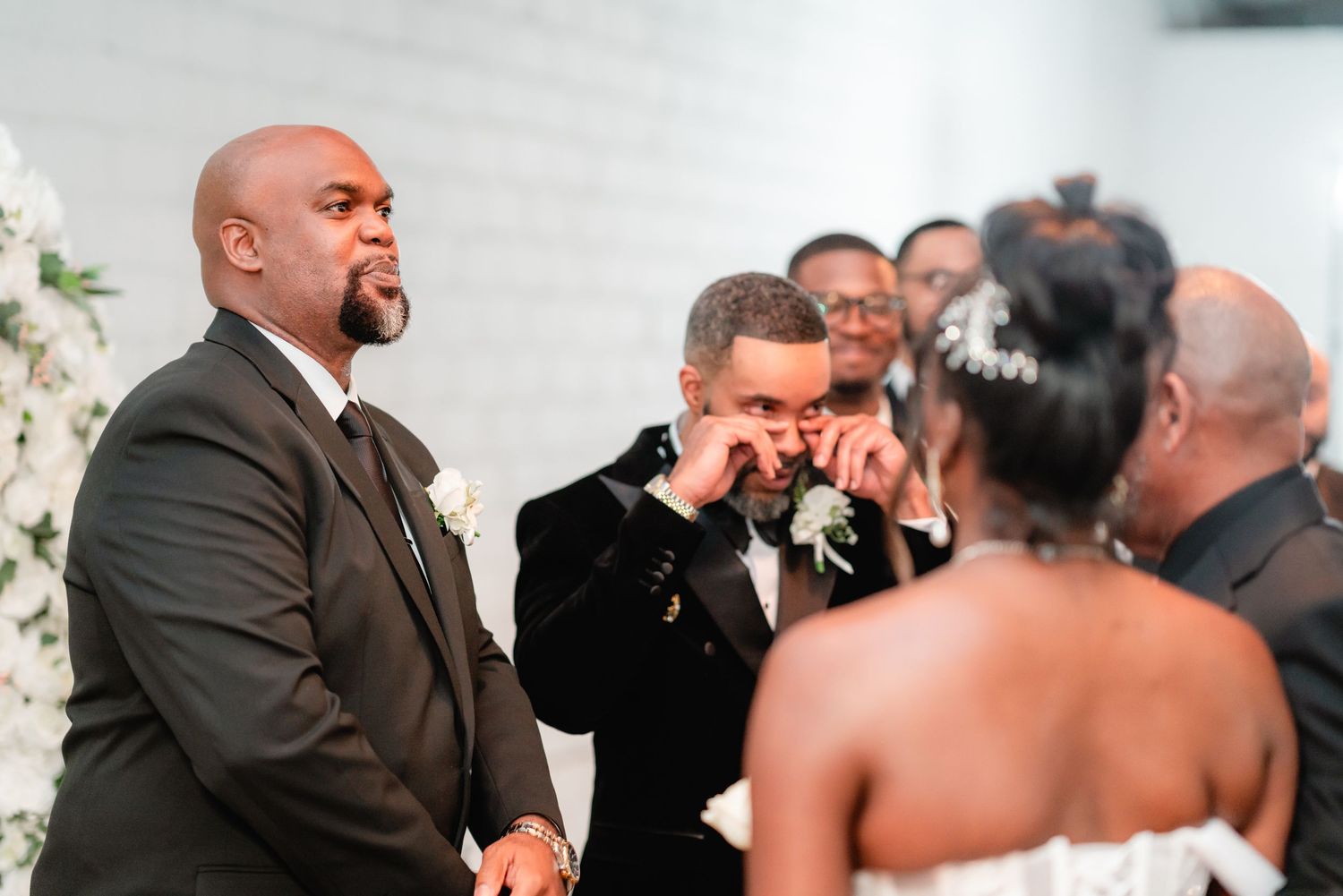 Intimate wedding ceremony moment captured in an industrial-style venue with white walls.