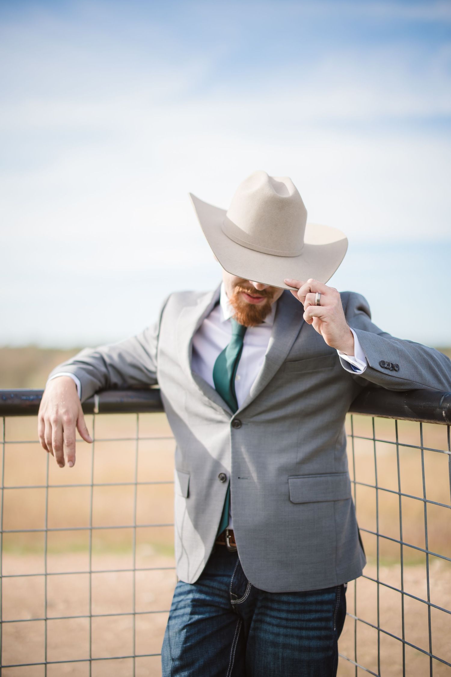 Four sequential photos show someone in a gray suit and white cowboy hat leaning against a rustic fence.