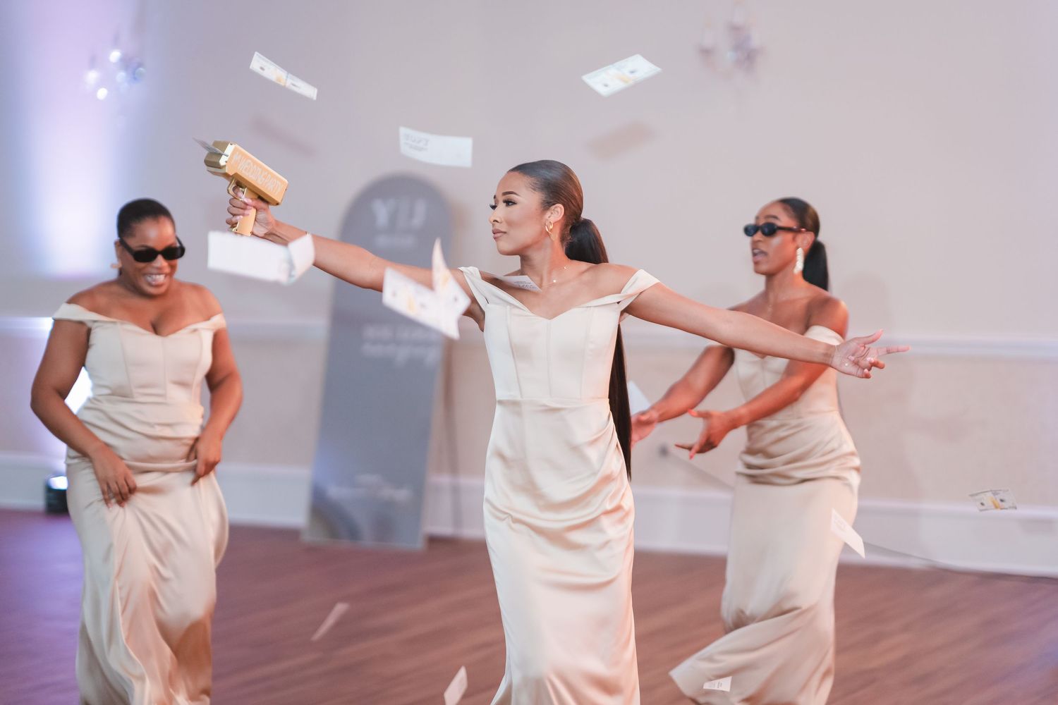 Wedding party performing choreographed dance moves in coordinated white outfits.