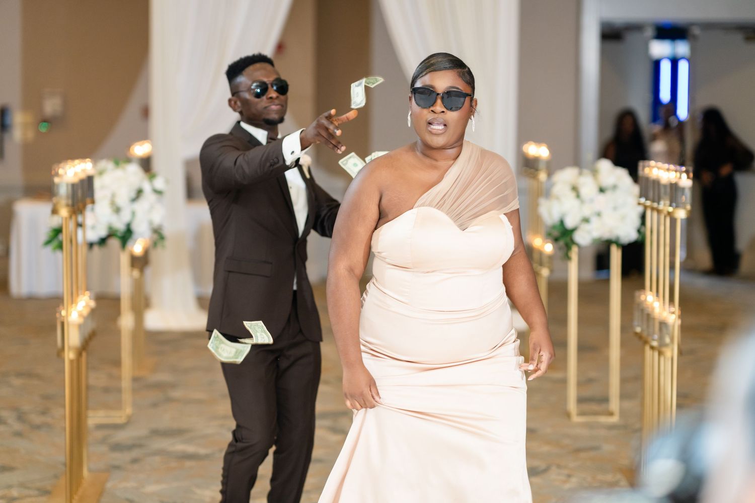 Wedding party members in white attire dancing and celebrating at an elegant reception.