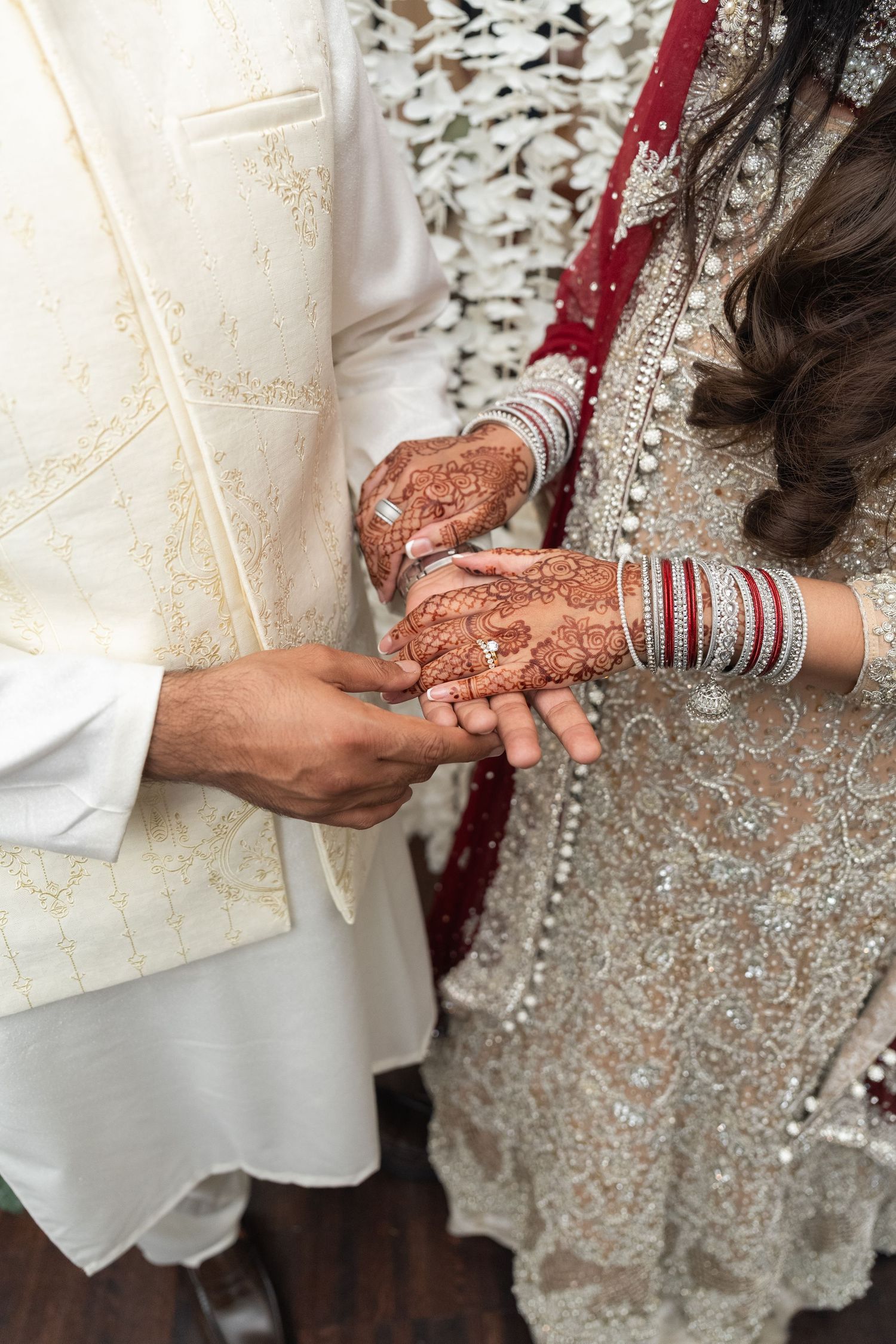 Close-up shots of hands with traditional henna designs and bangles during an Indian wedding ceremony.