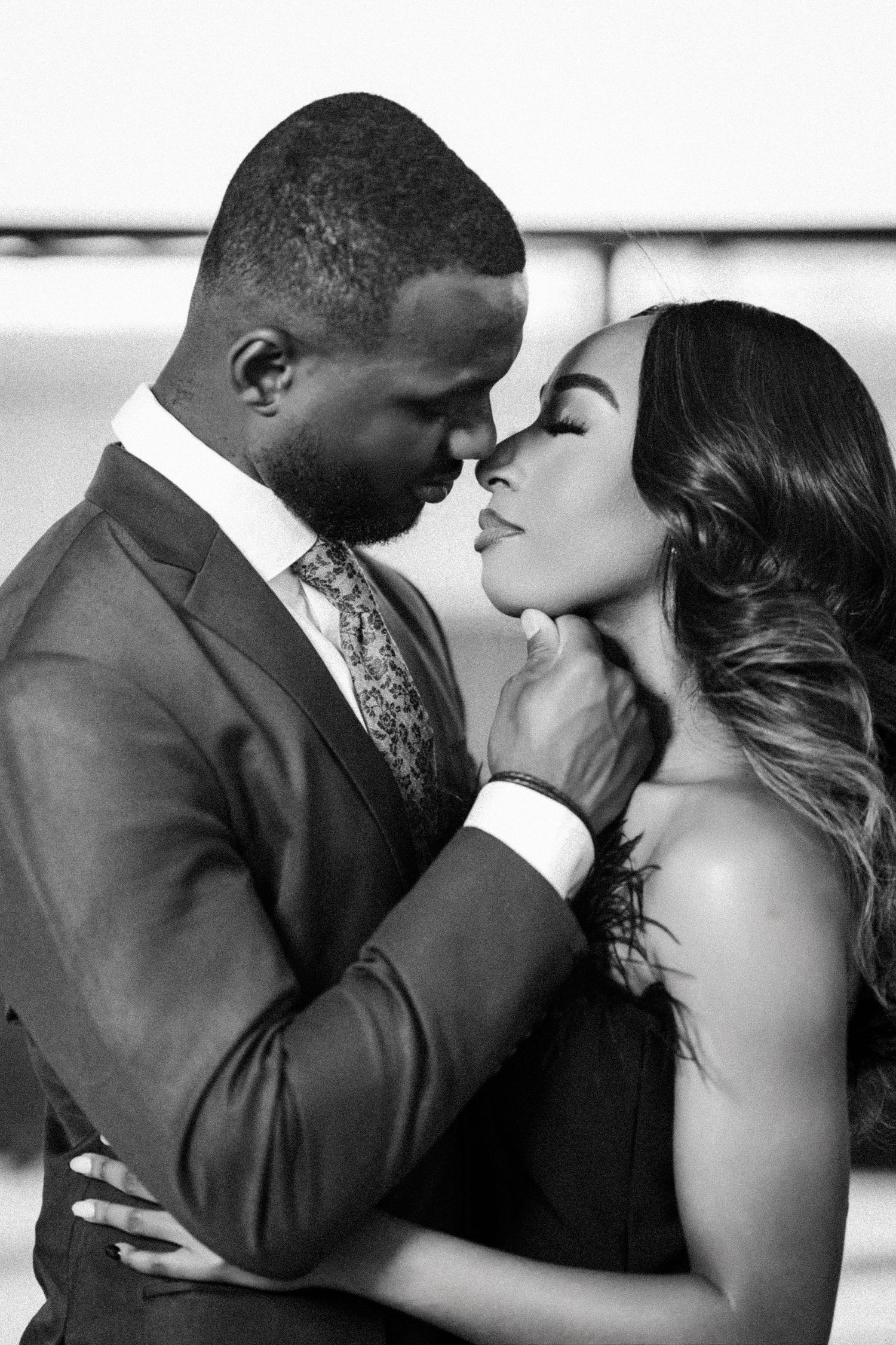 Couple in formal wear shares passionate kisses during professional photoshoot.