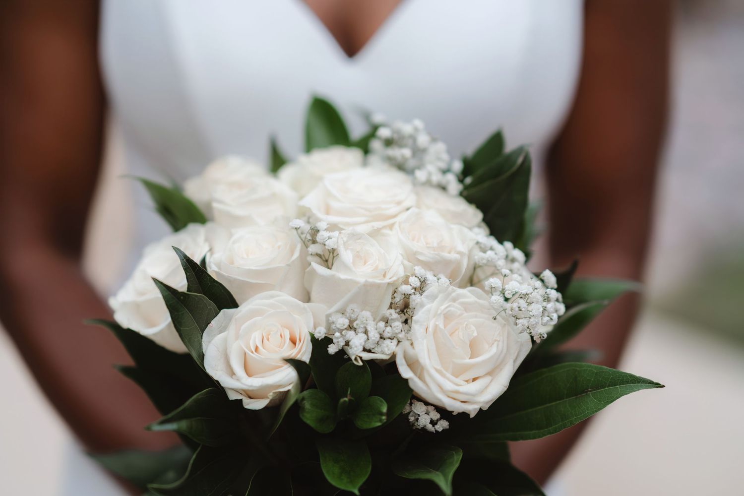 Elegant white roses and delicate baby's breath flowers arranged in a bridal bouquet.