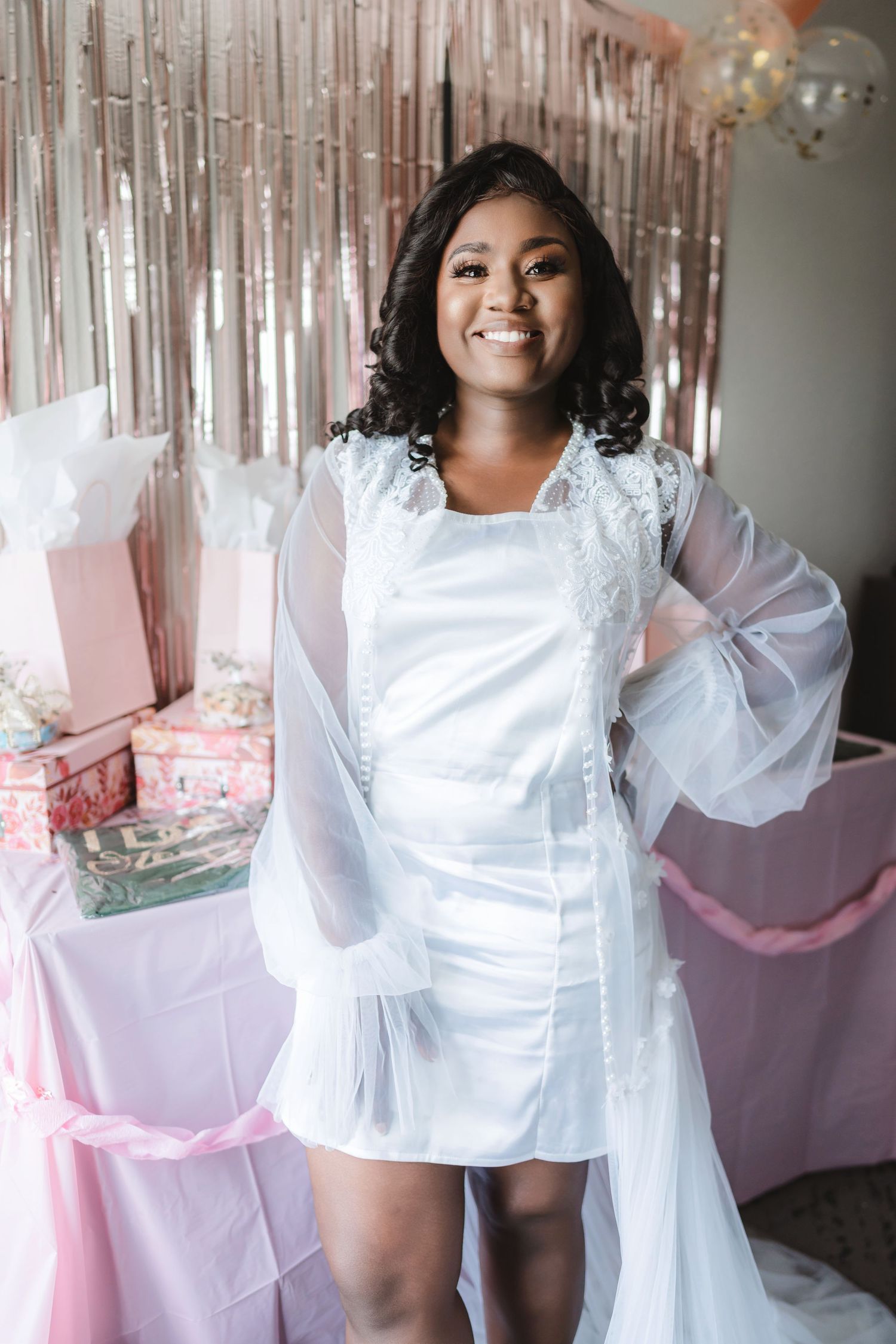 Bridal preparation scene with white dress and pink decor backdrop.