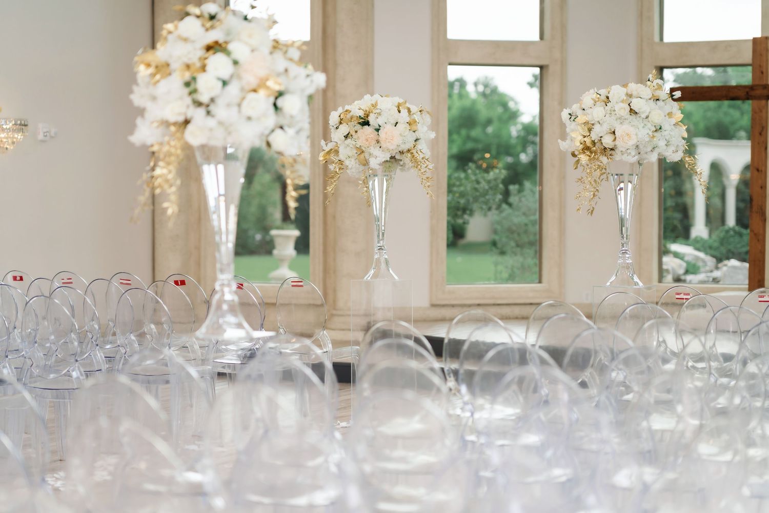 Elegant wedding reception table setup with crystal glassware and white floral centerpieces in a bright venue.