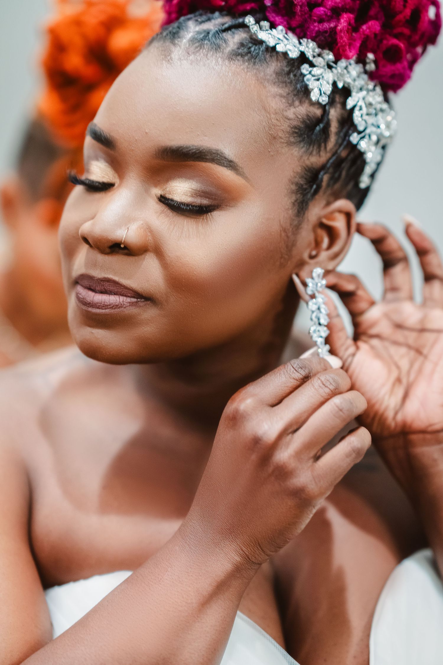 Elegant bridal portrait showing detailed makeup and sparkling hair accessories with a magenta updo.