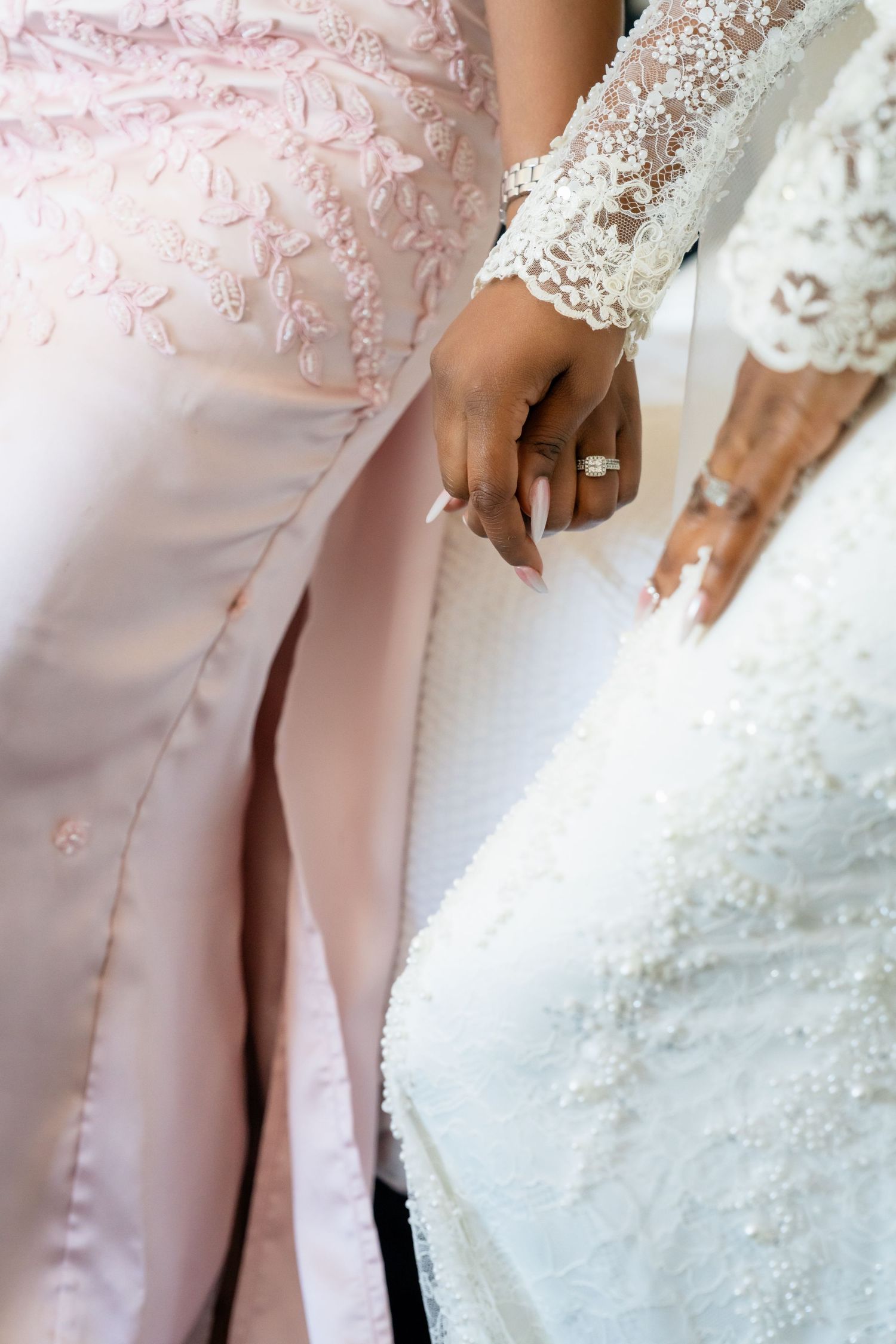 Close-up detail of pink and white lace wedding attire with delicate embellishments.