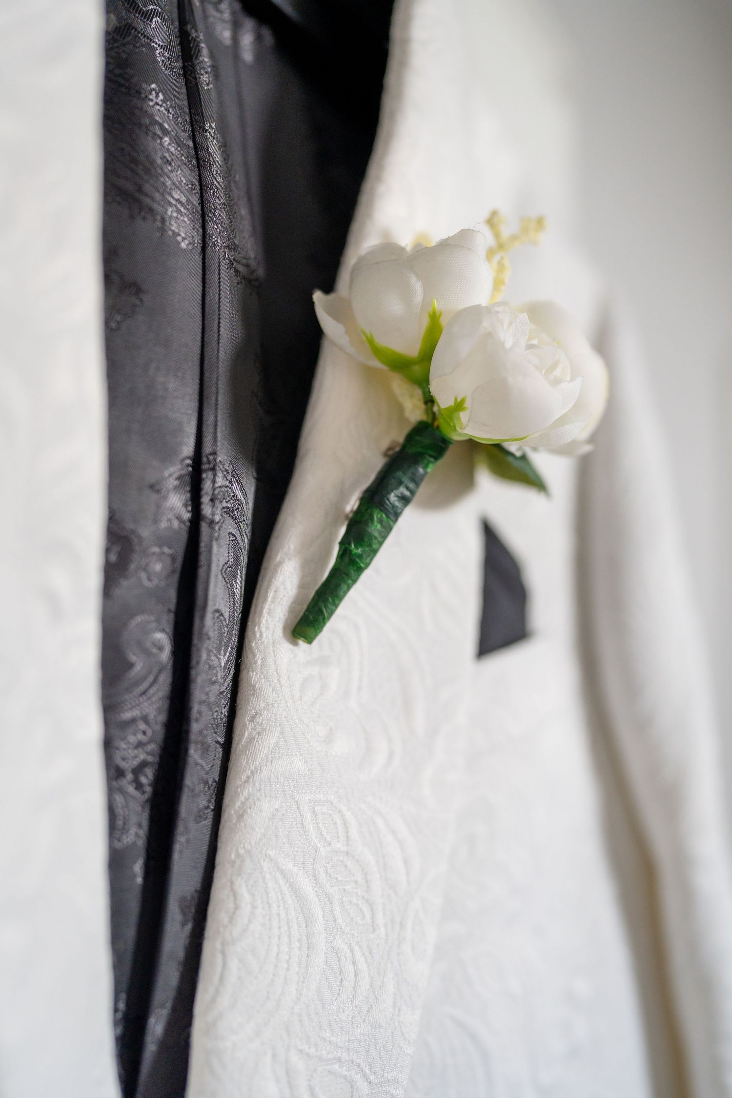Close-up details of a white wedding dress with delicate lace patterns and floral accents.