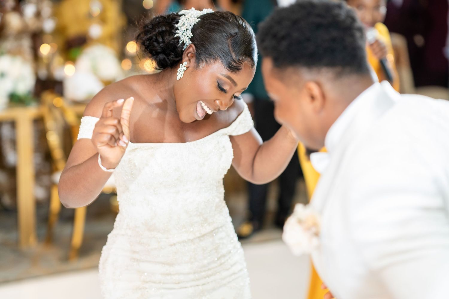 Wedding celebration moment showing couple in white attire during outdoor reception.
