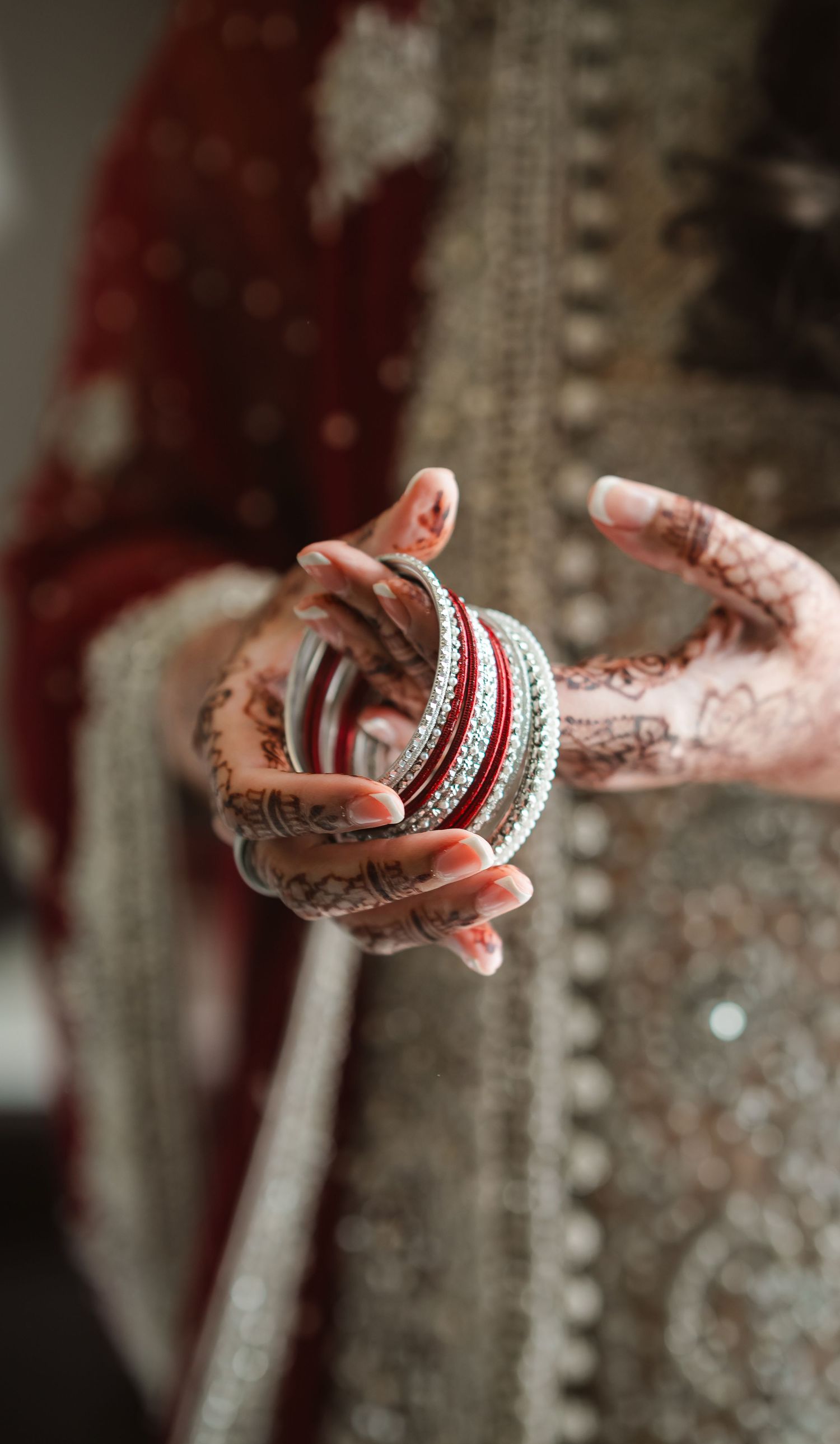 Close-up sequence of hands adorned with henna and wedding bangles showing intricate traditional bridal jewelry details.