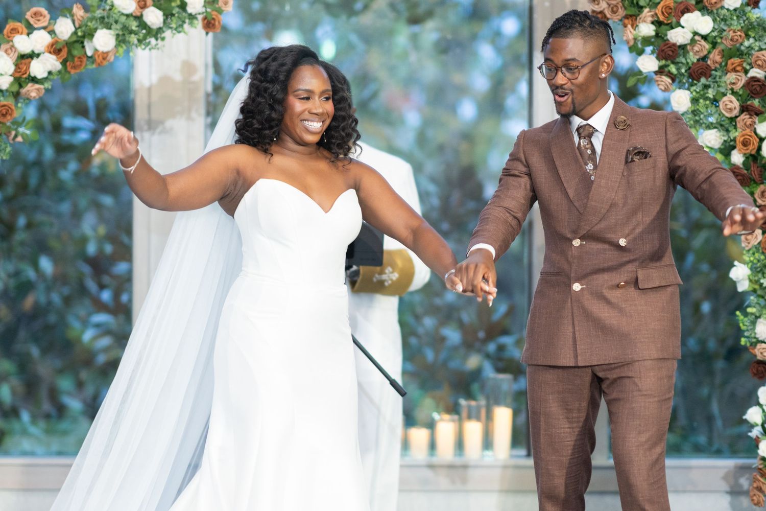 Wedding couple shares romantic moments against a floral backdrop outdoors.
