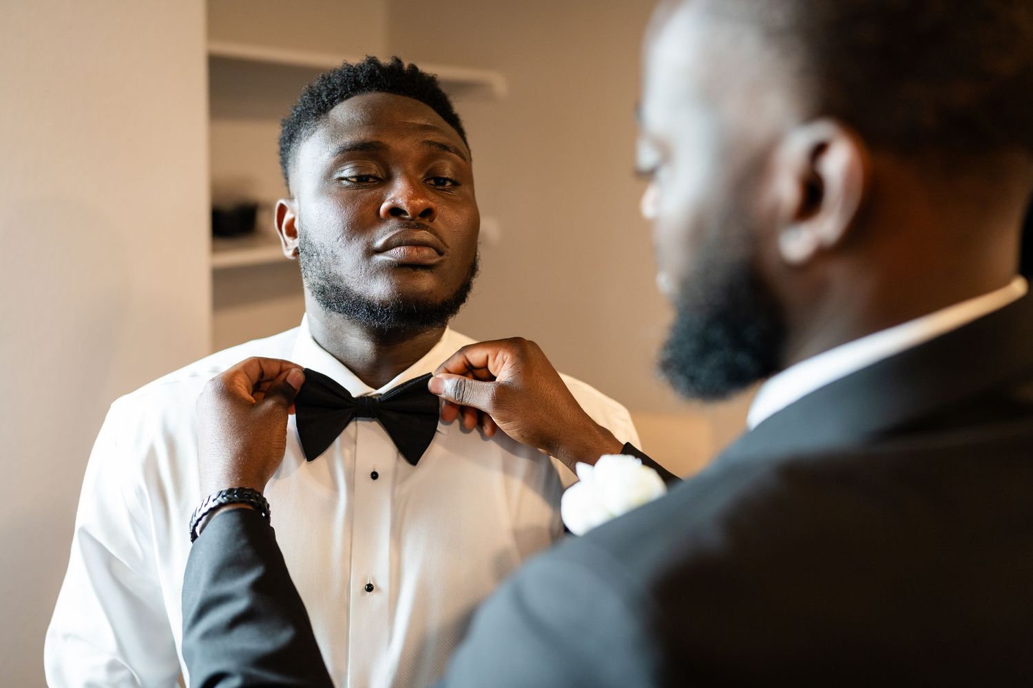 Groomsmen in formal attire getting ready before a wedding ceremony.