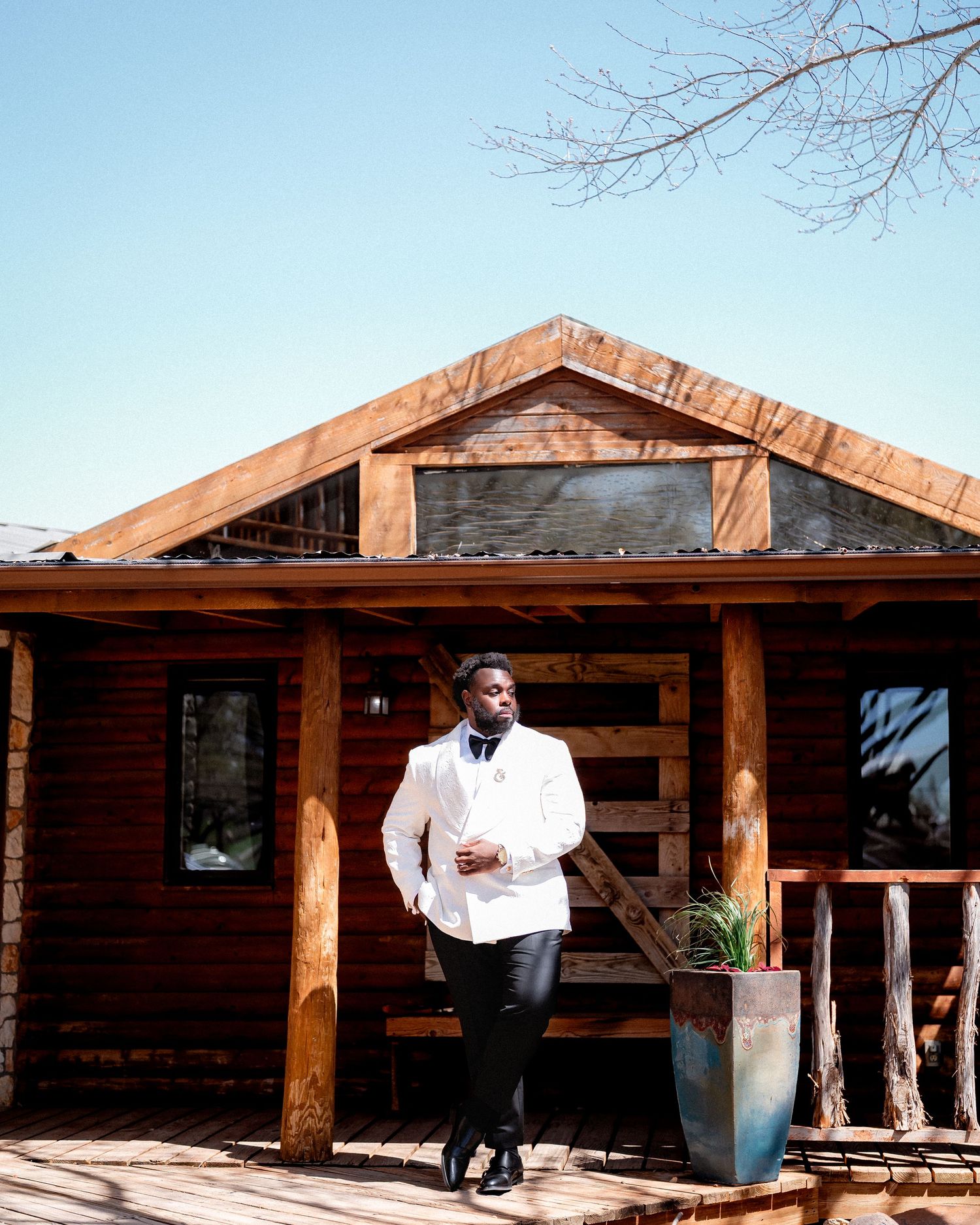 Rustic wooden porch with timber beams and white exterior at a wedding venue on a sunny day.