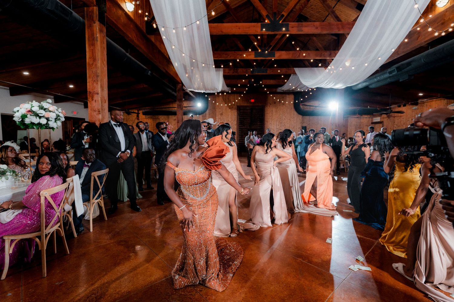 Wedding reception dance floor with white draping and warm lighting in a rustic venue.