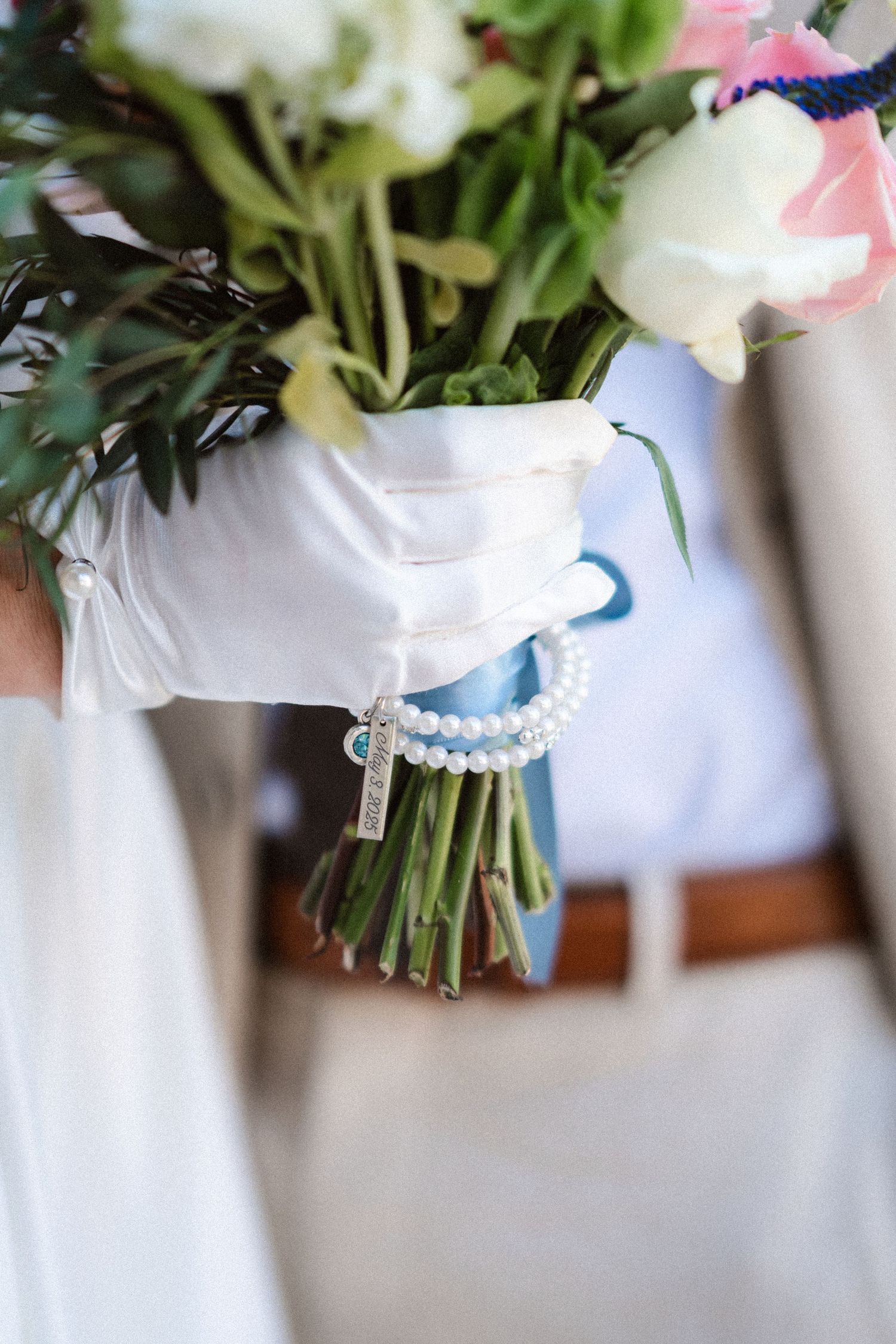 Wedding bouquets with white and pink flowers tied with ribbons displayed in a row.