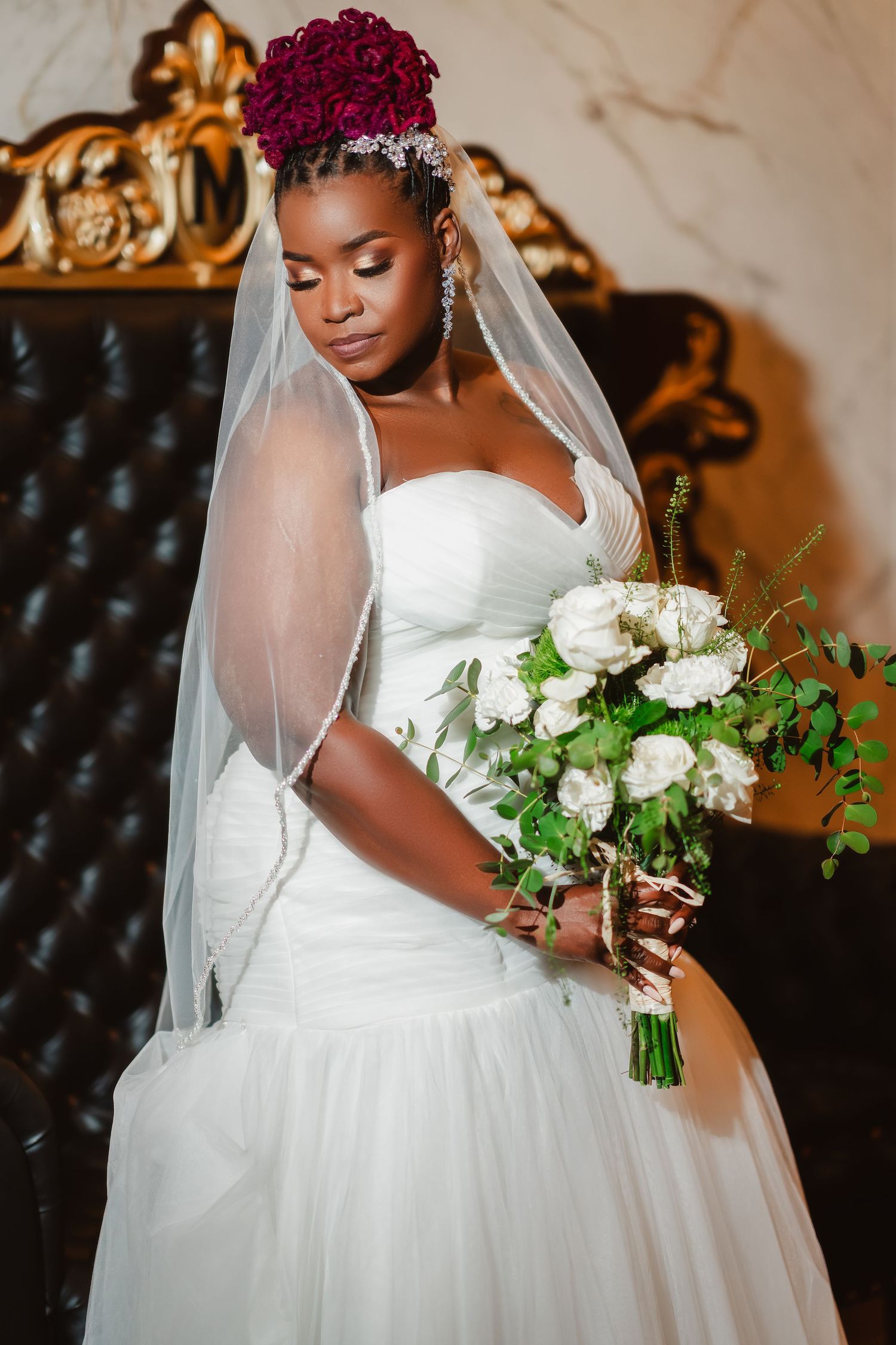 Elegant wedding photos showing a white ballgown dress with a flowing veil and white floral bouquet against dark backdrop.