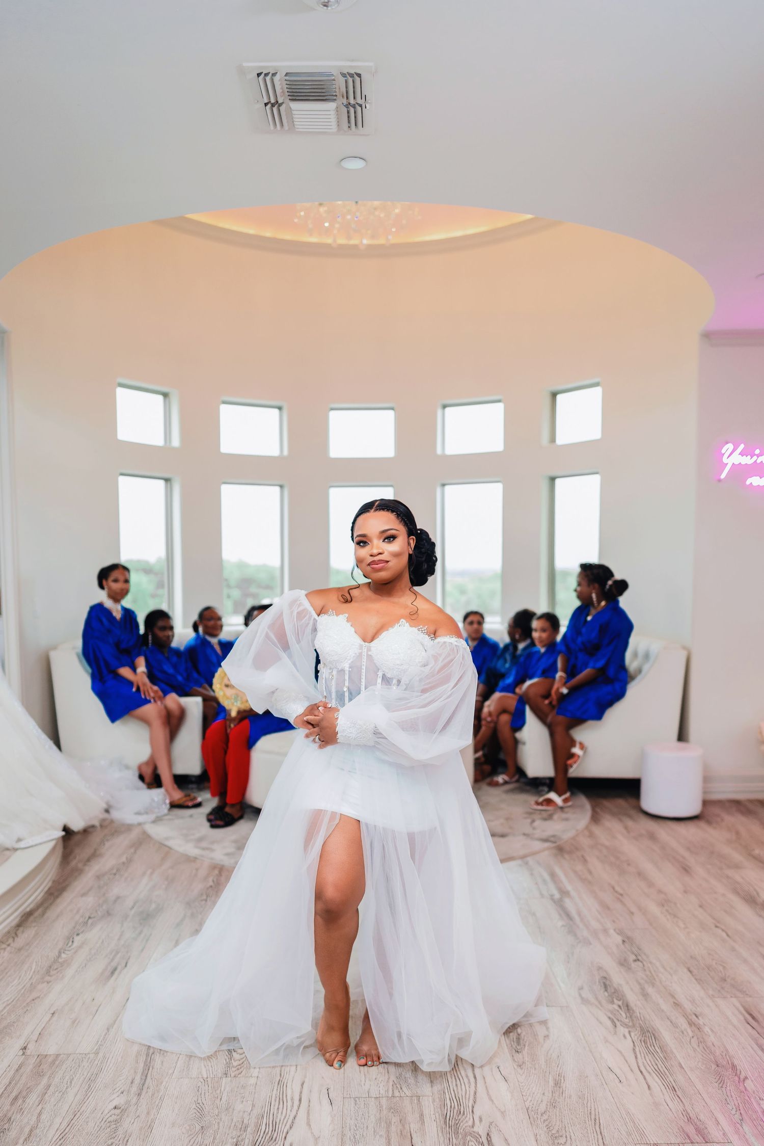 Wedding celebration in a bright white room with bridesmaids in blue dresses.