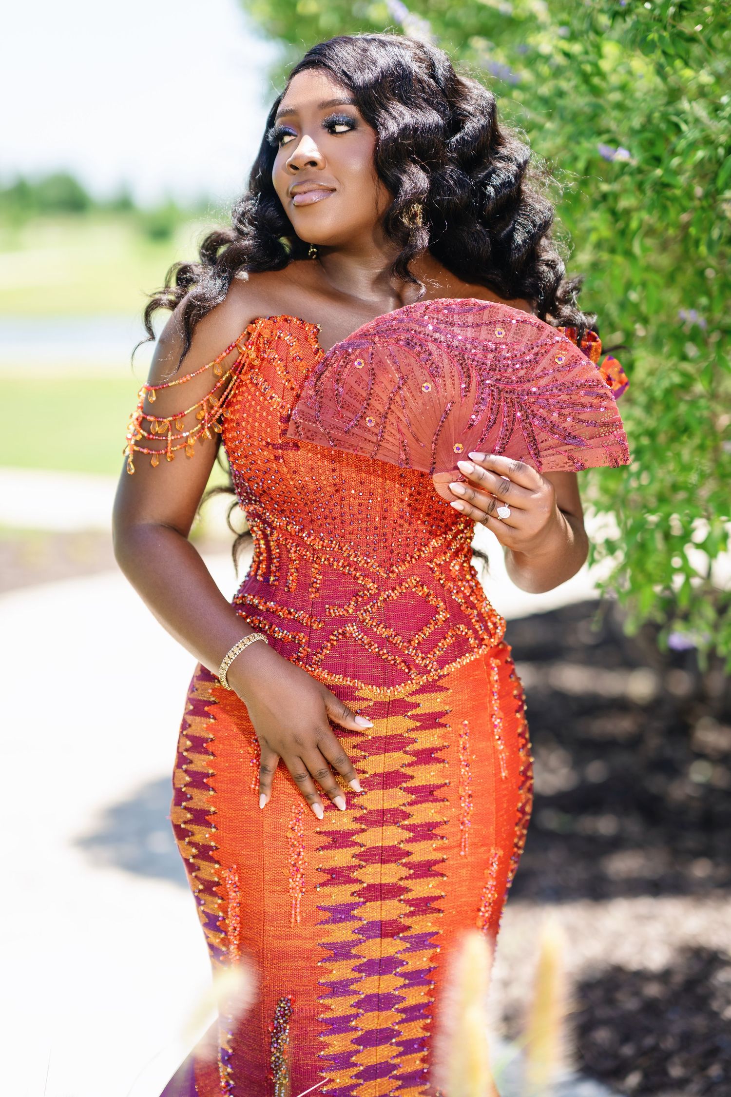 Close-up details of orange beaded formal dress with intricate patterns.